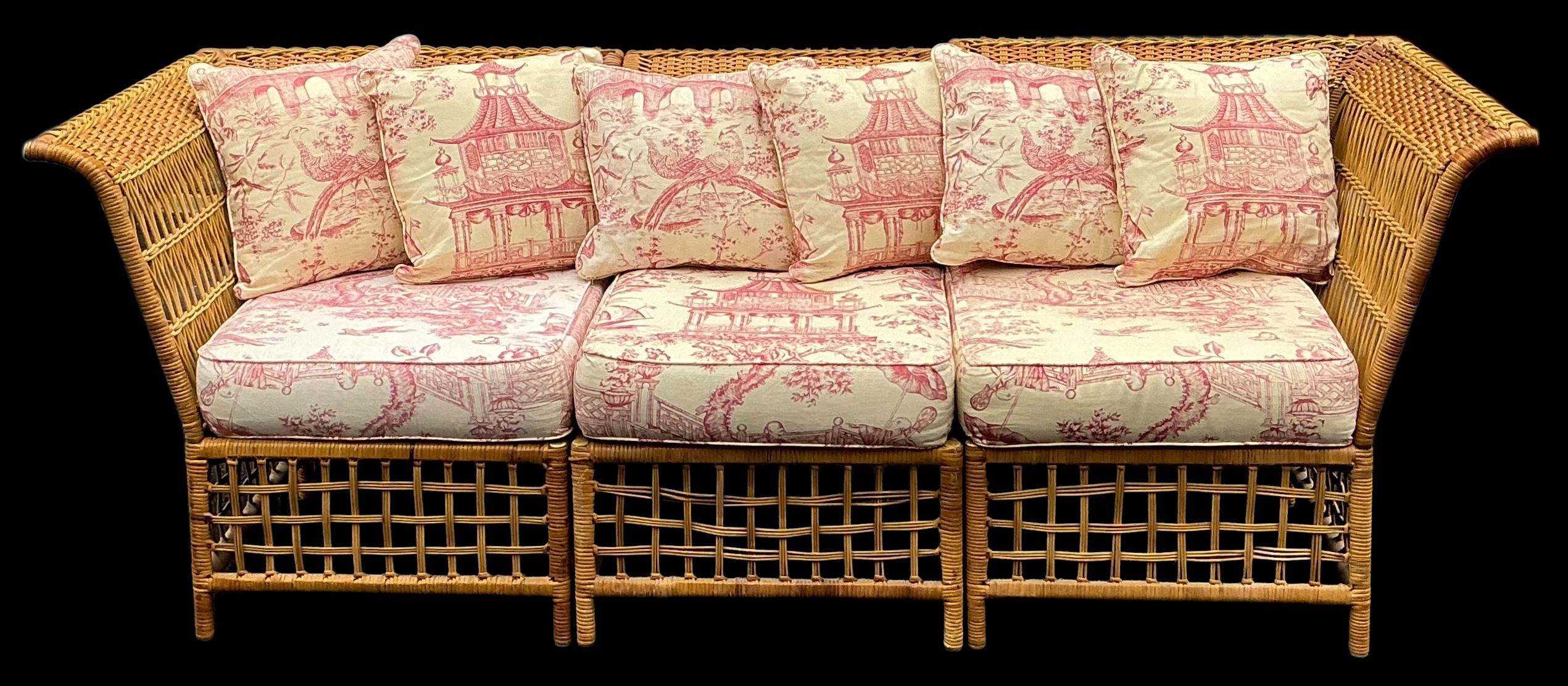 I like this piece! It is a three piece wicker sofa that can also convert into two chairs and an ottoman. The back of the middle section pulls out easily. The vintage upholstery is a printed pink and white chinoiserie. It shows some lite wear. The