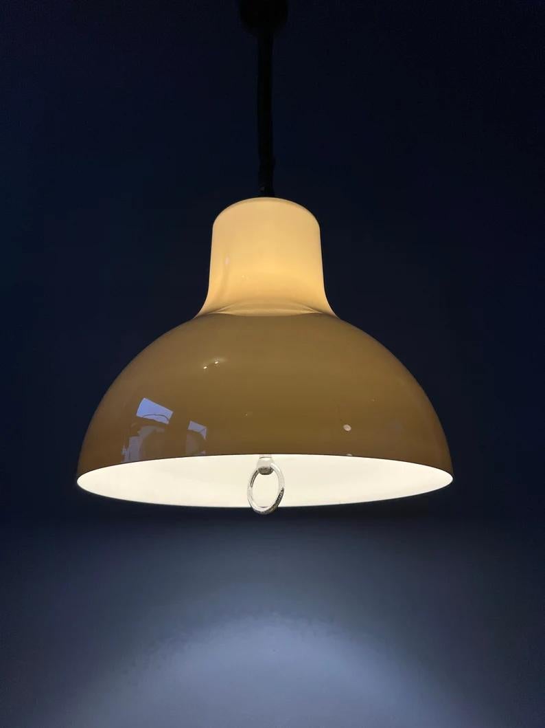 Rare space age pendant lamp with rise-and-fall. The acrylic glass shade has a beige, mocca colour and produces a warm, cosy light. The lamp requires one E27/26 lightbulb.

Additional information:
Materials: Metal, plastic
Period: 1970s
Dimensions: ø