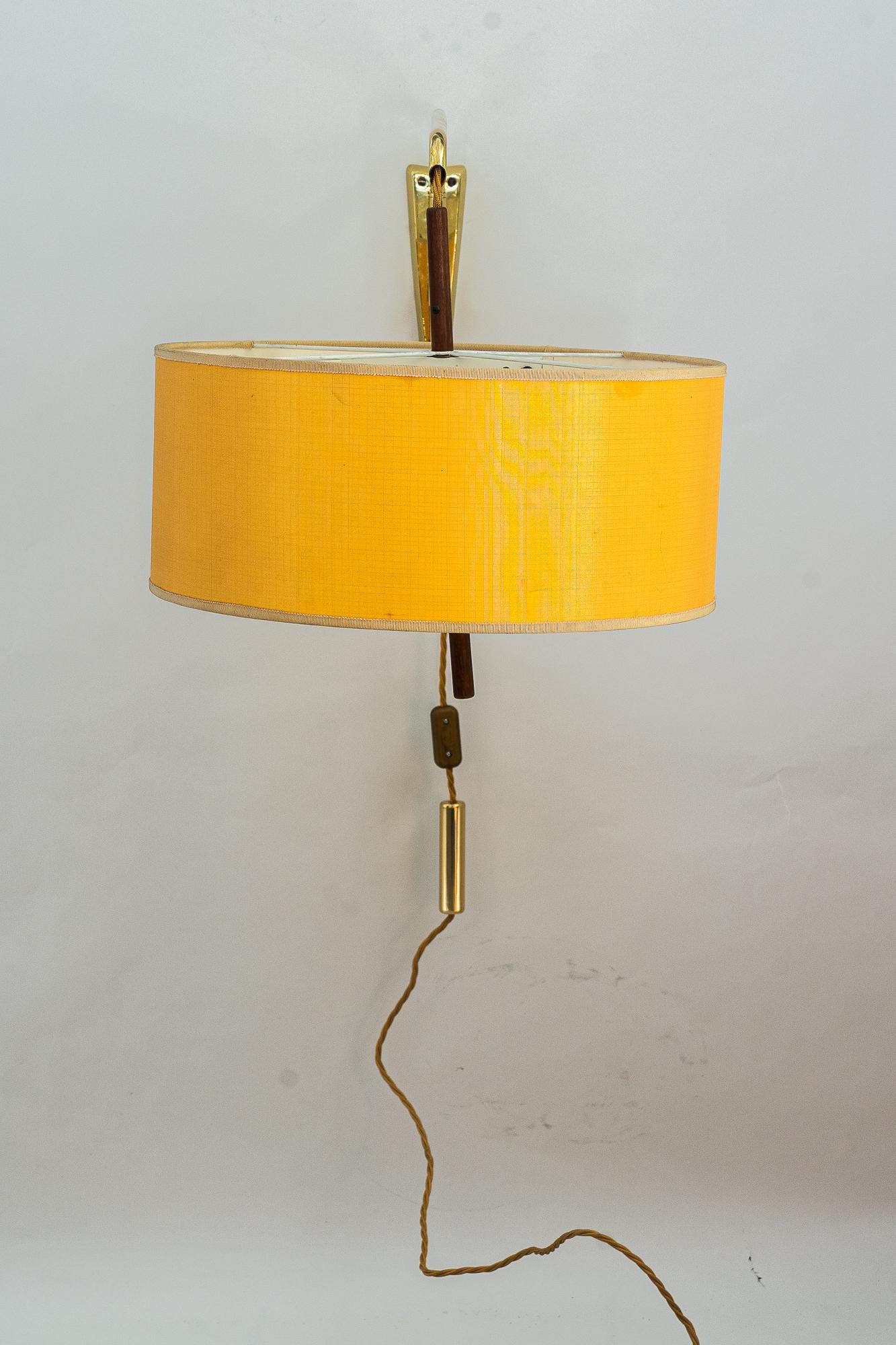 Adjustable big J.T.Kalmar wall lamp with original shade around 1950s
Hight adjustable from 44cm - 72cm
Wide: 40cm
Deep: 92cm

Brass, wood and fabric.
Original fabric shade
Original condition
Wire is replaced (new).