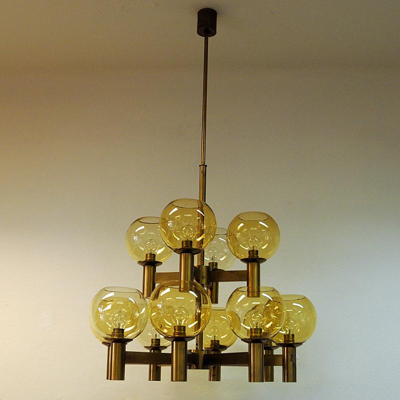 Big, majestic and massive midcentury Ceiling Lamp in the manner of Hans Agne Jakobsson consisting of a solid brushed brass stome and yellow colored glassdomes. The ceilinglamp has nine beautiful glassdomes with golden shimmer in which gives a really