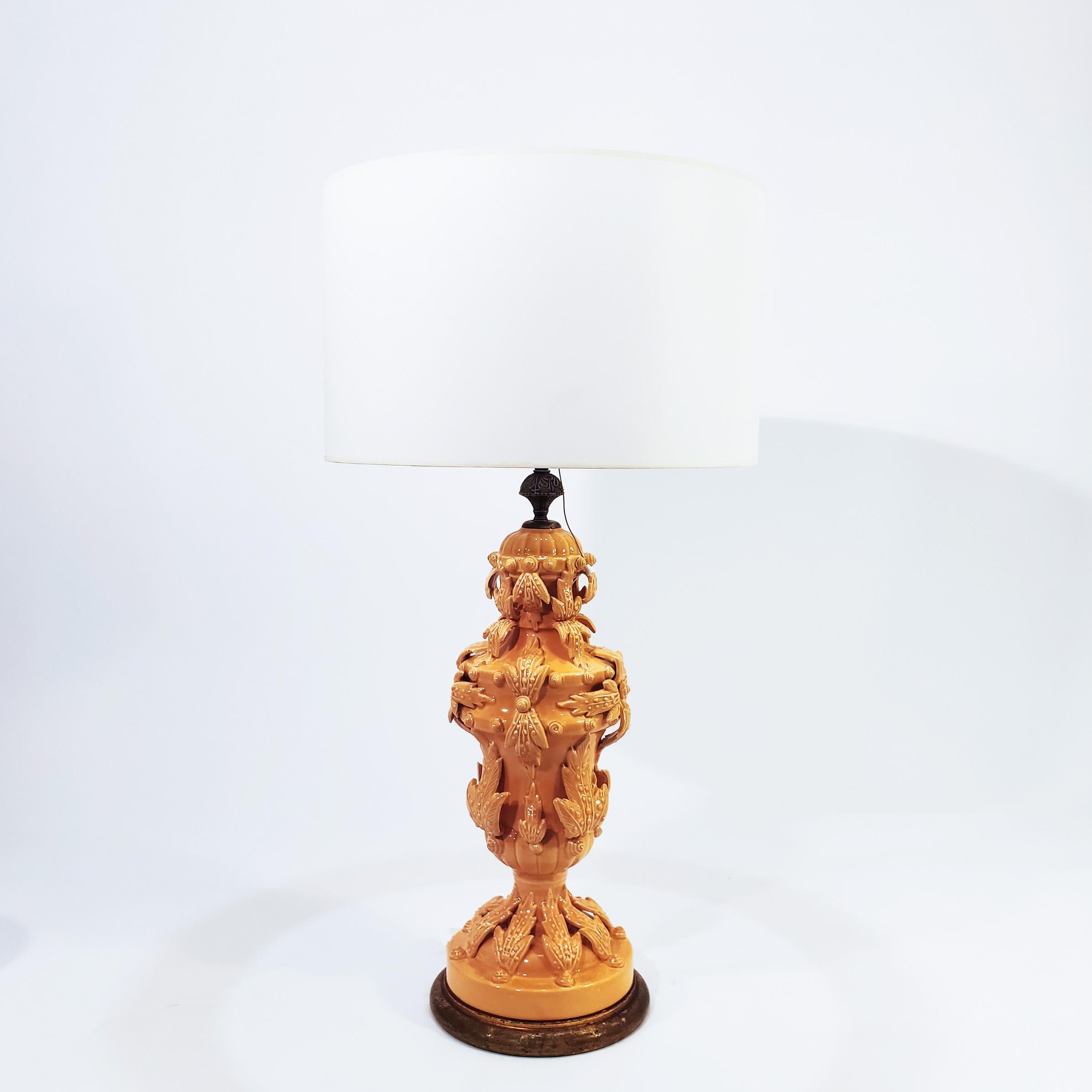 Bondia table lamp produced in Spain in the 60s, in the style of Manises lamps. Ceramic body rich in floral and plant motifs, in a peach/salmon tone. Wooden base finished in gold leaf and top rosette in golden brass.
For an E27 bulb. Original