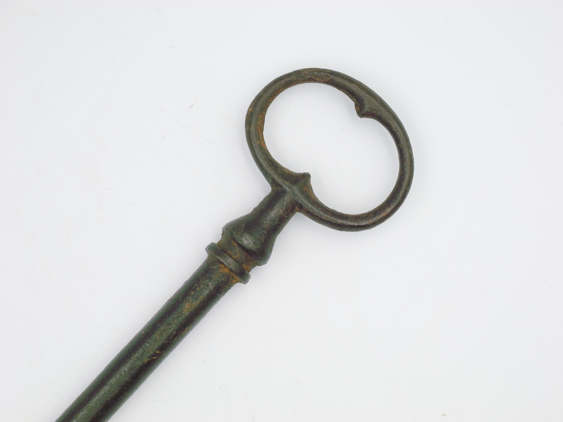 This Antique 17th-century wrought iron key is a fascinating artifact that transports us back to an era of intricate craftsmanship and timeless elegance. This key, crafted with wrought iron, showcases the skill and artistry of blacksmiths from the