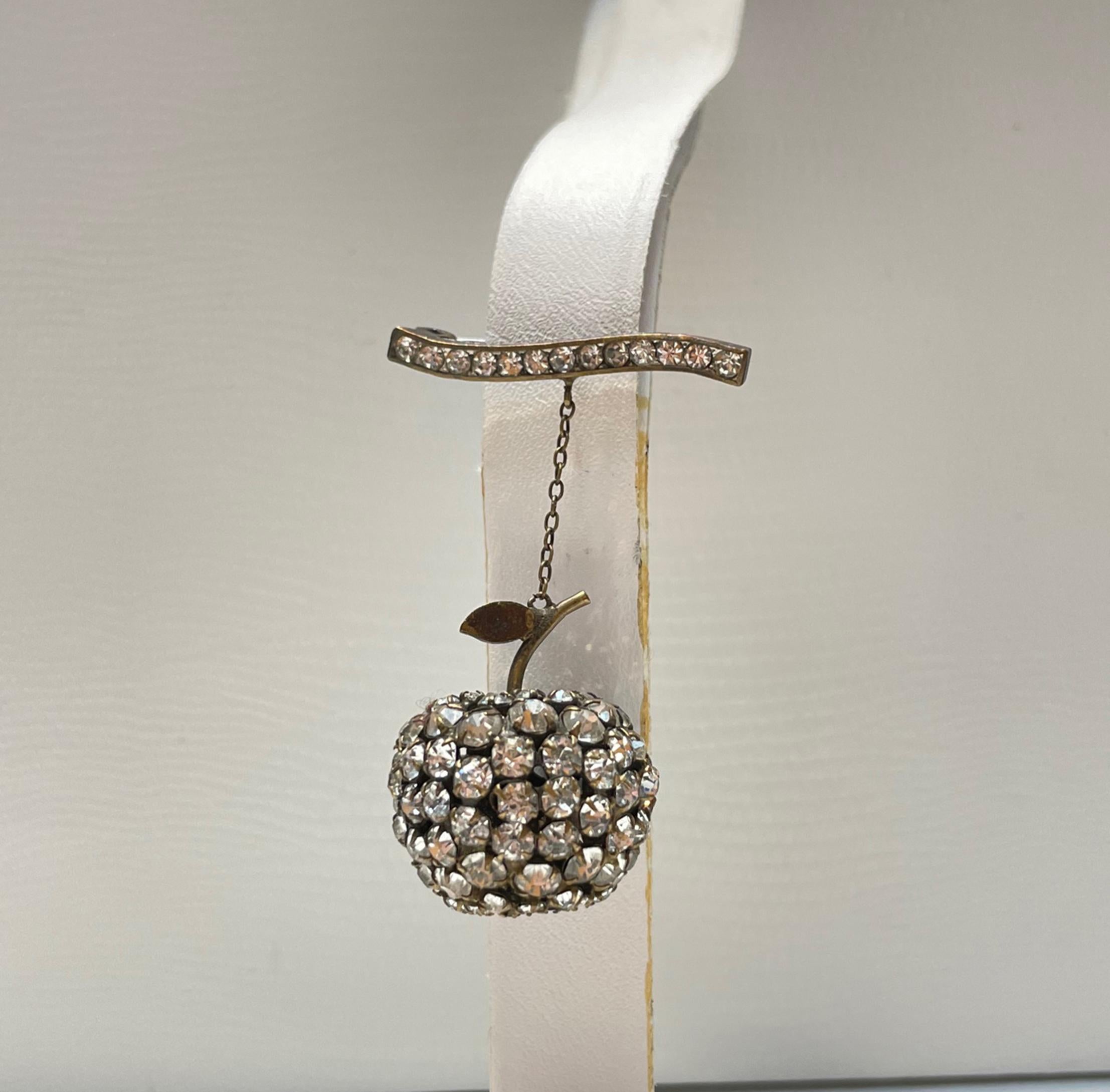Beautifully designed Art Deco Brooch featuring an Apple encrusted with Sparkling Crystals suspended from a Crystal encrusted Bar. Silver mounting. Measuring approx. 1.75” long. More Beautiful in real time...Chic and sure to be admired complement to