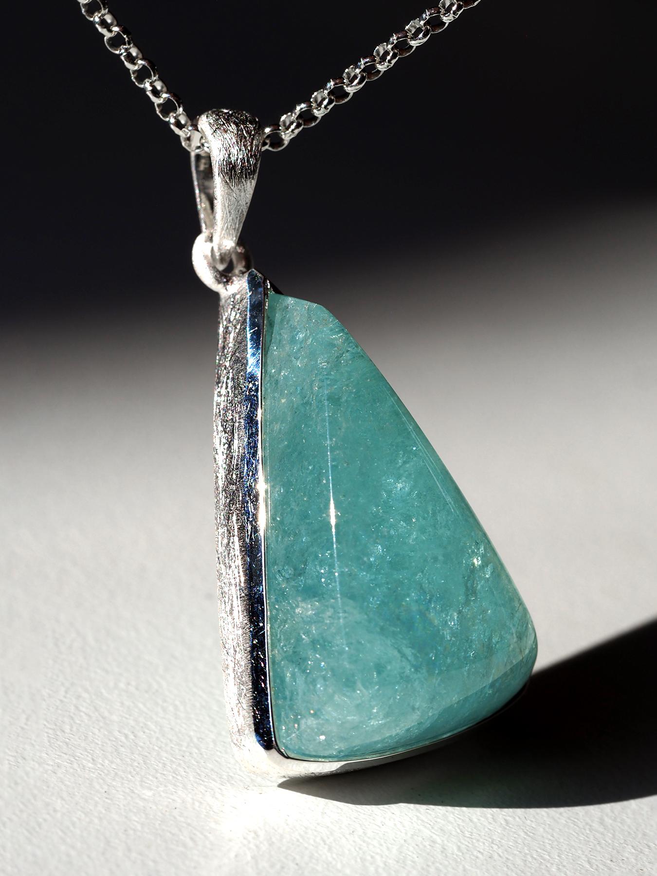 Un ciondolo scultoreo con un'acquamarina naturale di 33,7 carati, ammirata per la sua morbida tonalità blu oceano e la naturale profondità di colore. Estratta in Brasile, la gemma mostra un delicato movimento interiore e un sereno gioco di tonalità