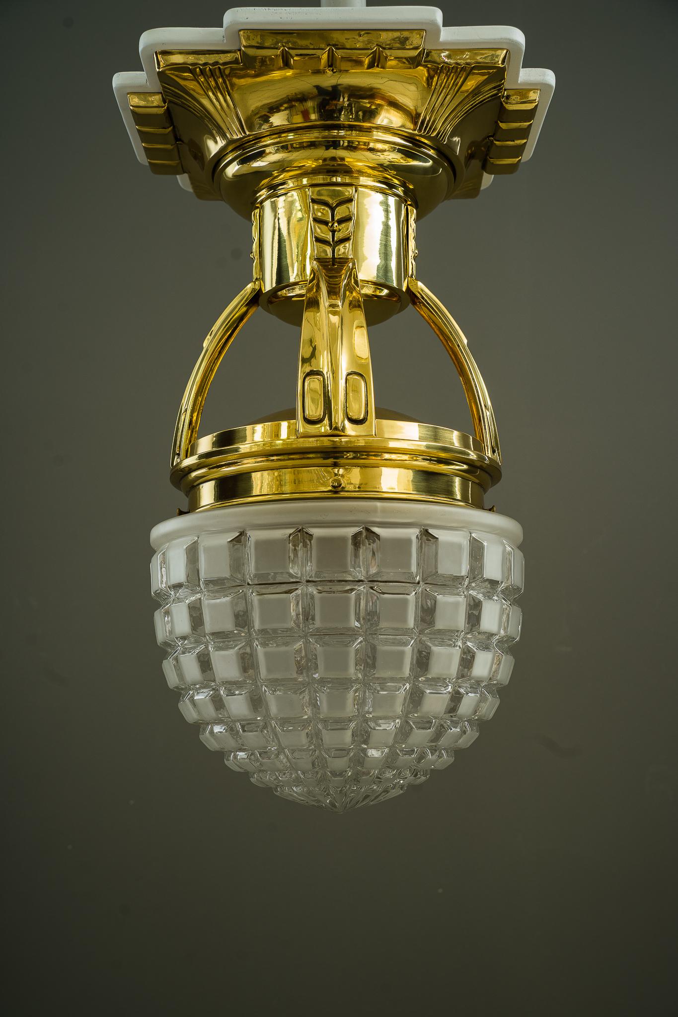 Big Art Deco ceiling lamp Vienna around 1920s.
Brass polished and stove enameled.
Original glass shade.
Wood plate white painted on top (new wood plate).