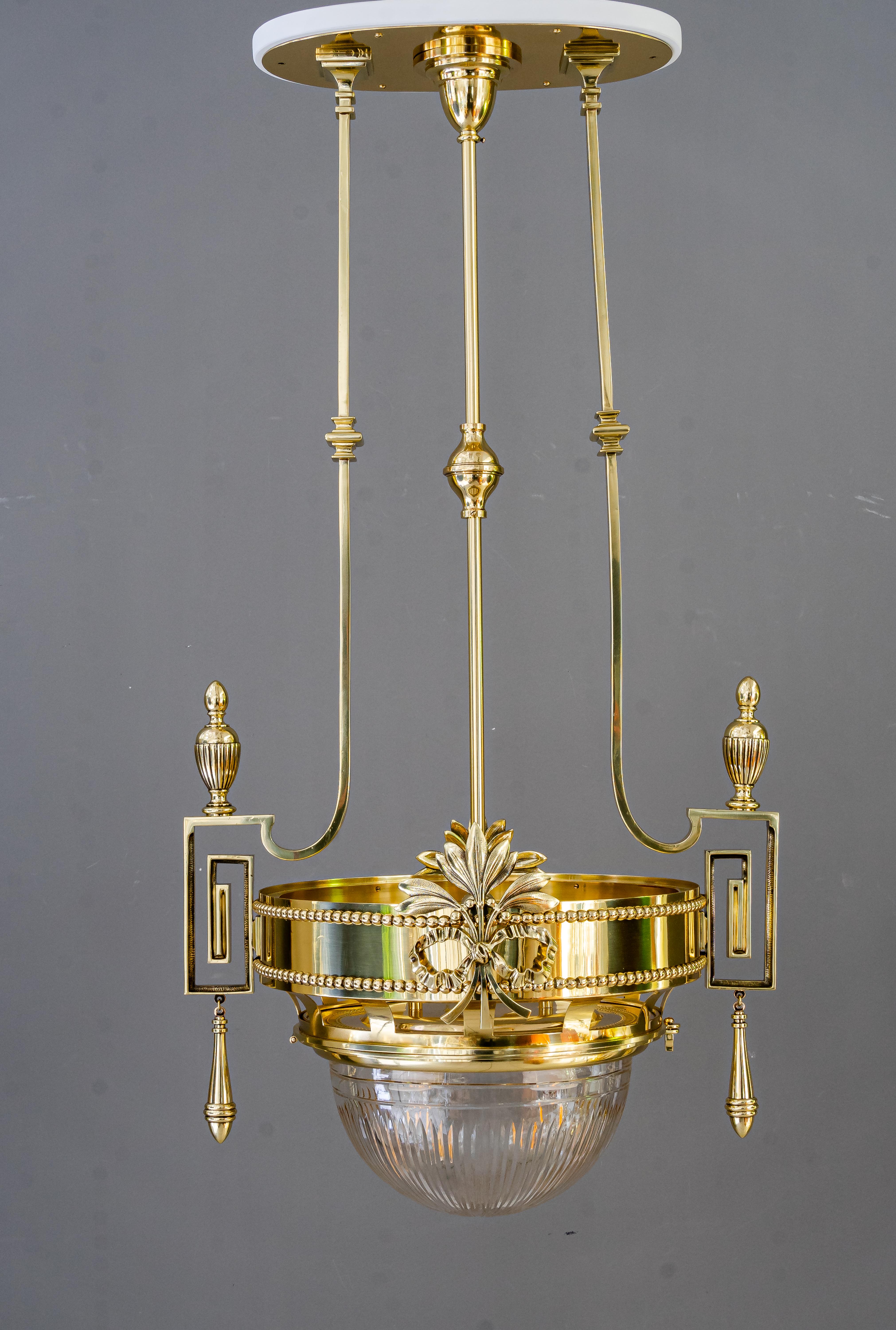 Grand lustre Art Deco viennois vers 1920
Laiton poli et émaillé au four
Abat-jour original en verre taillé