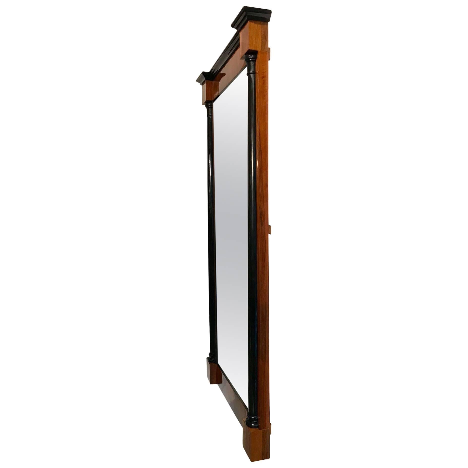 Beautiful, rare and big neoclassical Biedermeier wall mirror from South Germany, circa 1830.
Walnut veneered and hand polished with shellac (French polished). Two ebonized half columns and old mirror glass.