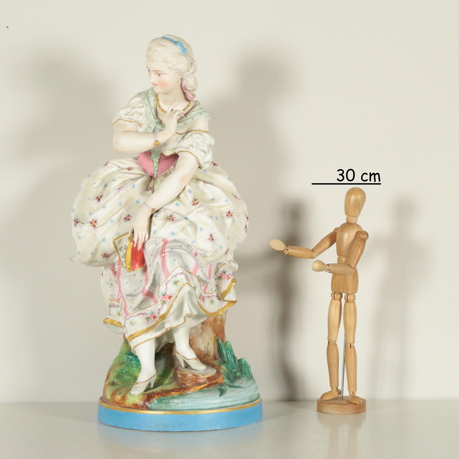 Big bisque sculpture decorated with a polychromed young lady wearing an 18th century dress and holding a music score.