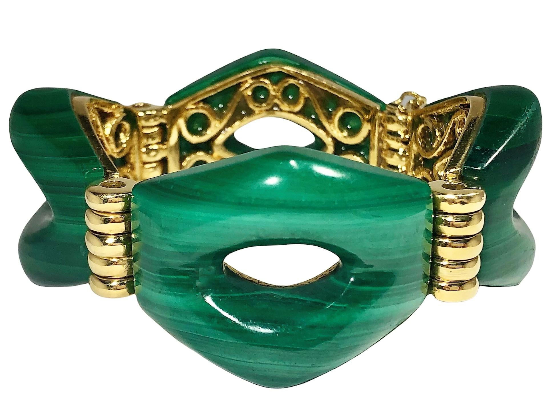 This very unique Mid-20th century bracelet is comprised of four massive hand fashioned malachite links, each measuring 1 1/2 inches by 1 1/8 inches, all seated on an intricately carved foundation of 18k yellow gold frames. Fluted yellow gold