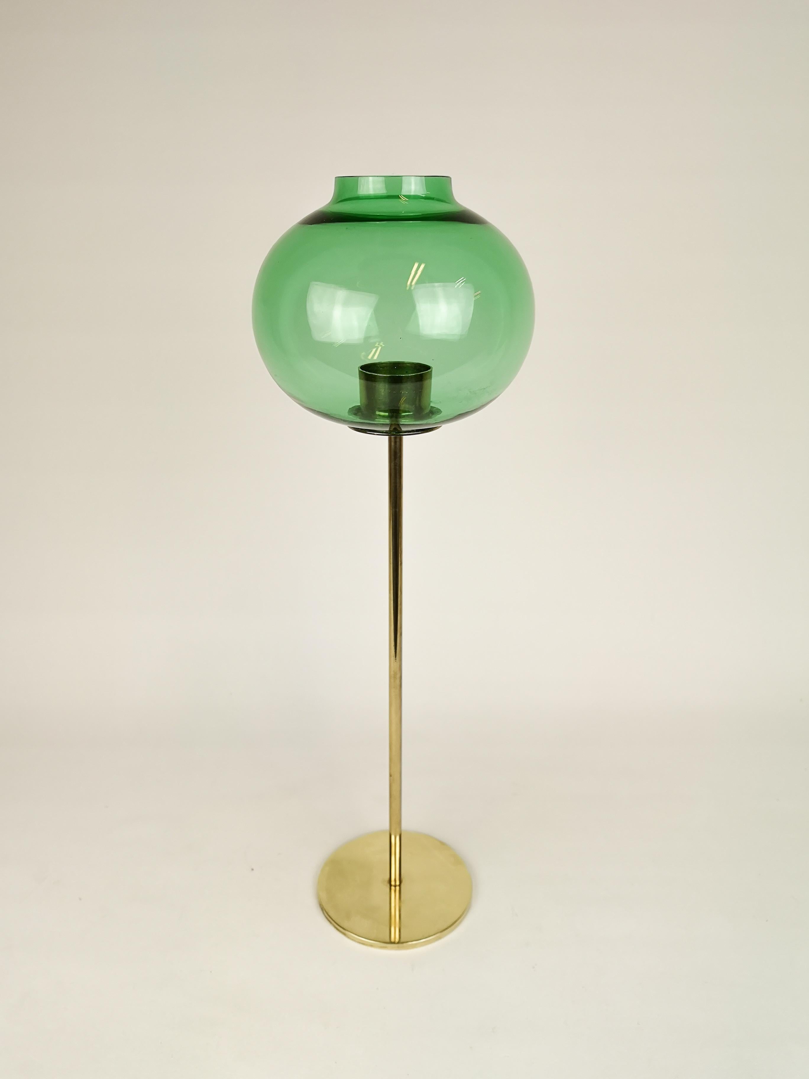 This candleholder was made in Sweden, 1960s and designed by Hans-Agne Jakobsson. It’s in brass and the top is made out of greenglass. 

It’s in good condition. The glass has a little chip around the opening, this is not visible when it’s on the
