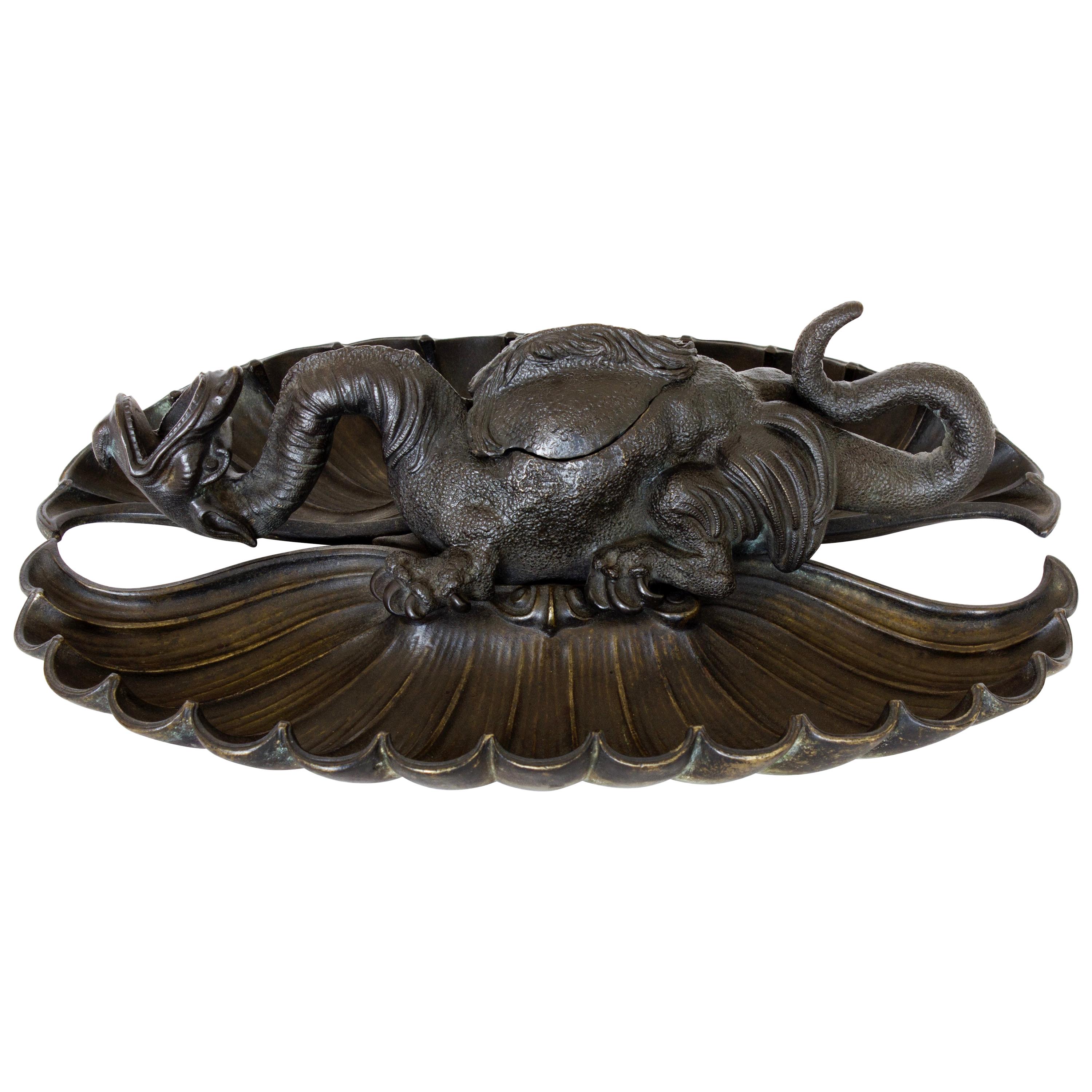 Bronze dragon standing on a stylized leaf.
Magnificent piece which shines with its originality and the chiseling work developed all-over its decors.
Dimensions: H 10 cm x W 31.5 x D 22.5 cm.