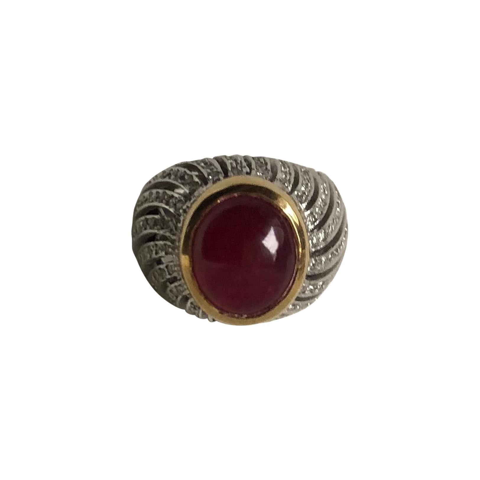 18kt yellow and white gold ring with estimated over 10 cts cabochon ruby  and diamonds. 
Oval cabochon ruby treated, non transparent, deep red colour, dimensions: 1.6 cm x 1.2 cm. 
110 Diamonds (round brilliant cut, weight of  1.20cts, color  H and