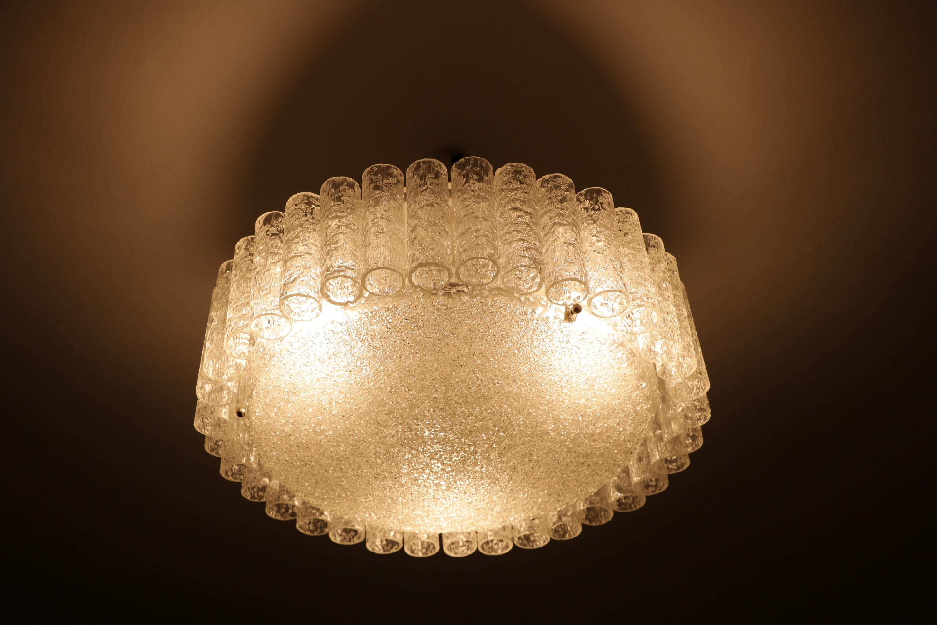 Flush mount or chandelier with 35 glass tubes made of ice glass and a large glass plate at the bottom, giving off an indirect, atmospheric light.
 
By DORIA.
 
50 cm / 19.68 inch diameter
25 cm / 9.84 inch height
 
6 x E27 sockets
Can be