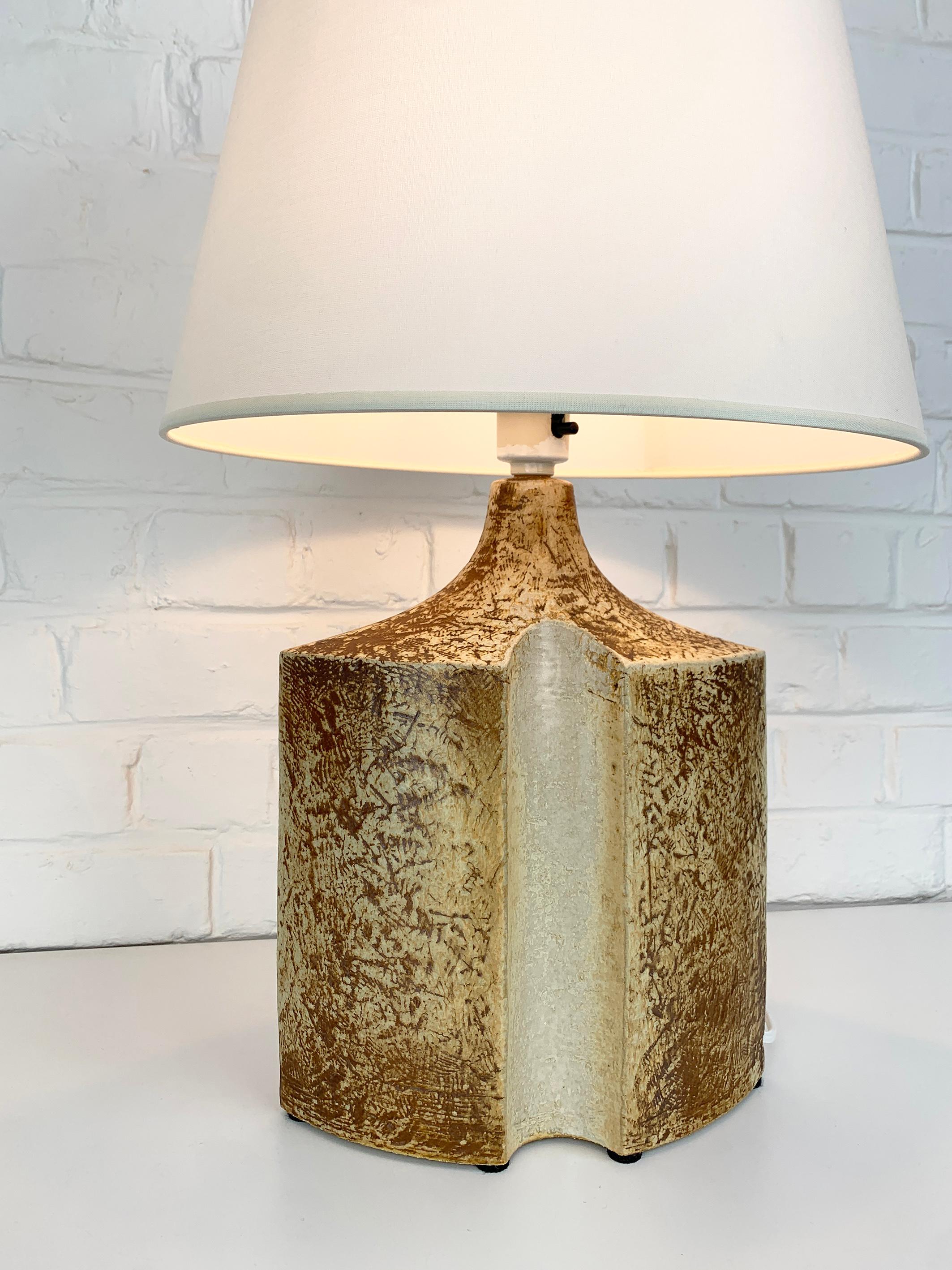 Danish Mid-Century stoneware table lamp of the 1970s by Haico Nitzsche. Sculptural lamp in earthy colored glazed stoneware. 

Haico Nitzsche trained in ceramics in Germany before teaching at the National Institute of Design in Ahmedabad, India in