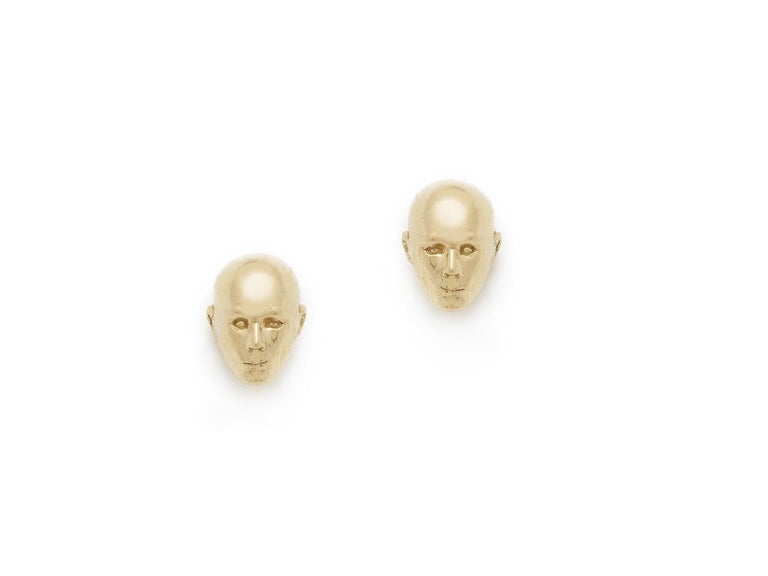 Two small faces made from 18k Gold.