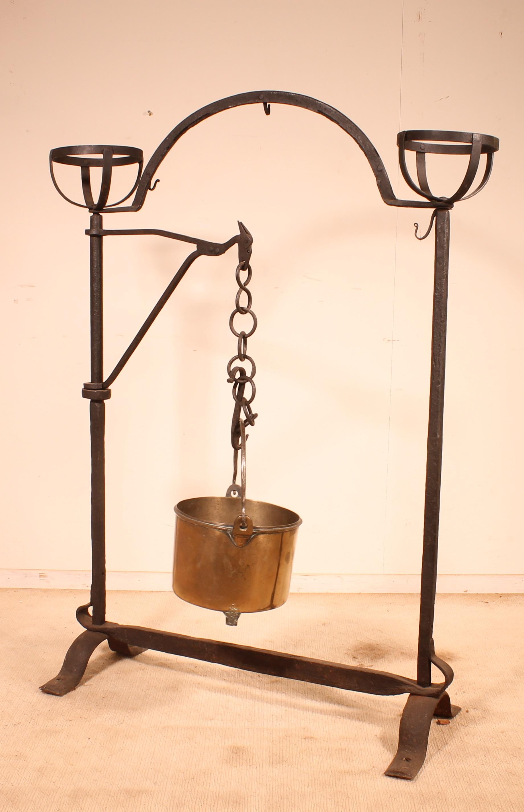 Superb wrought iron fire dog topped with wheels (baskets to keep embers or hot kettle)

Very beautiful work in wrought iron from the 17th century from Spain

The landier has a swivel arm allowing to hang a pot decorated with a horse beautiful