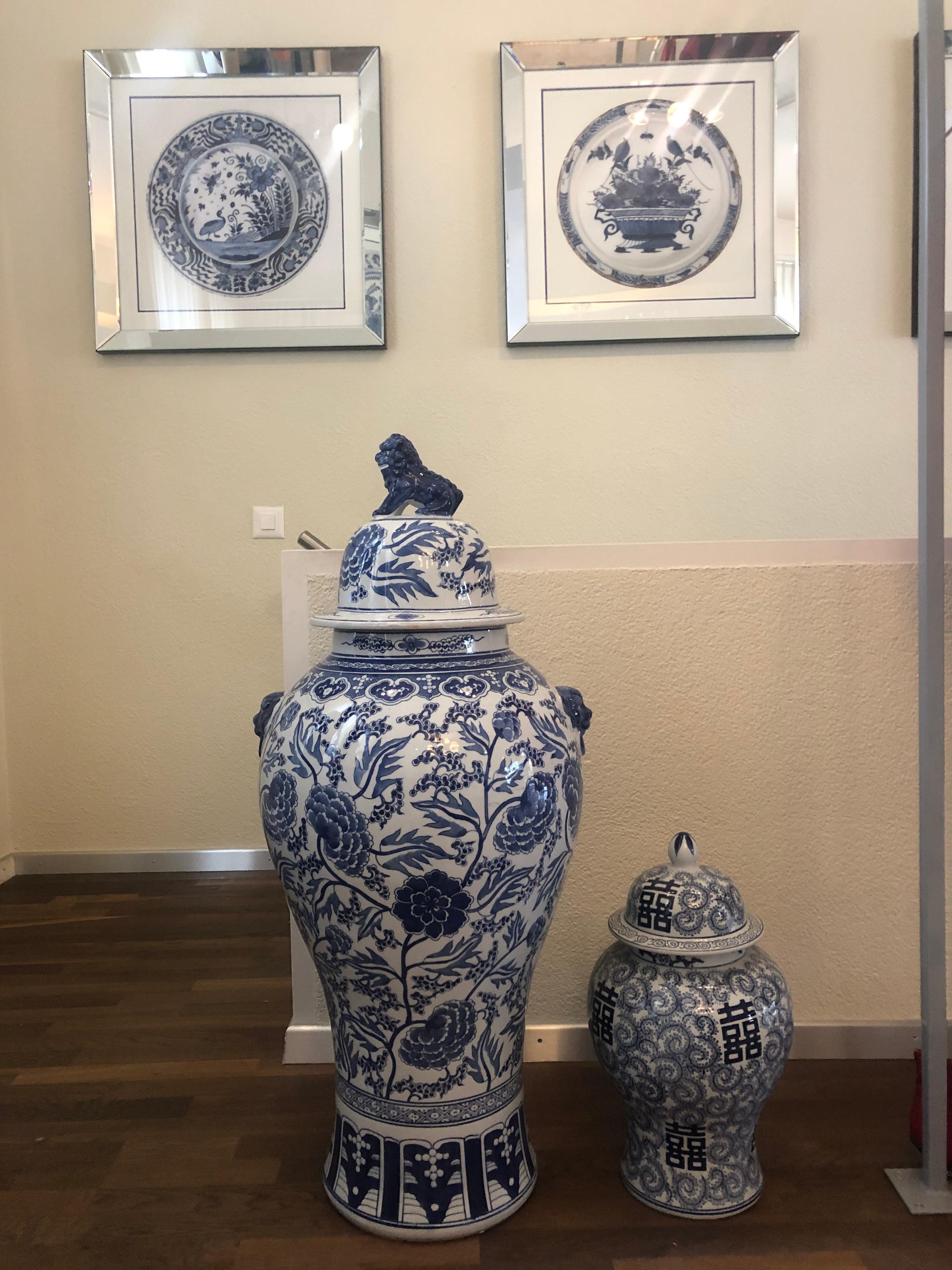 Blue and white Qing dynasty style Chinese covered vases painted in deep cobalt blue with a design of Tibetan flowers.