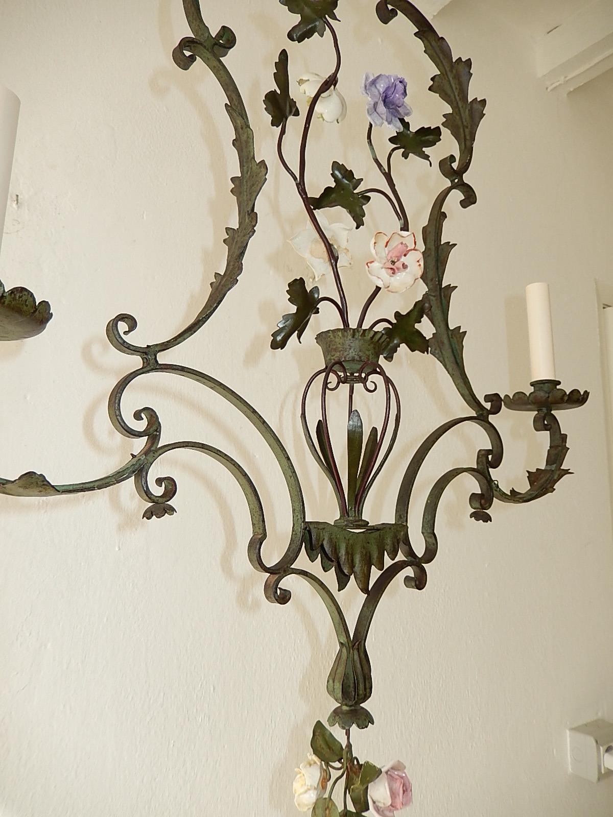 Housing 2 lights. Hand forged wrought iron one of a kind with handmade porcelain flowers. Chandelier is darker then it shows in the photos. Photo number 2 shows the closest of the true color in person. Also adorning a tassel of roses as finial. Look