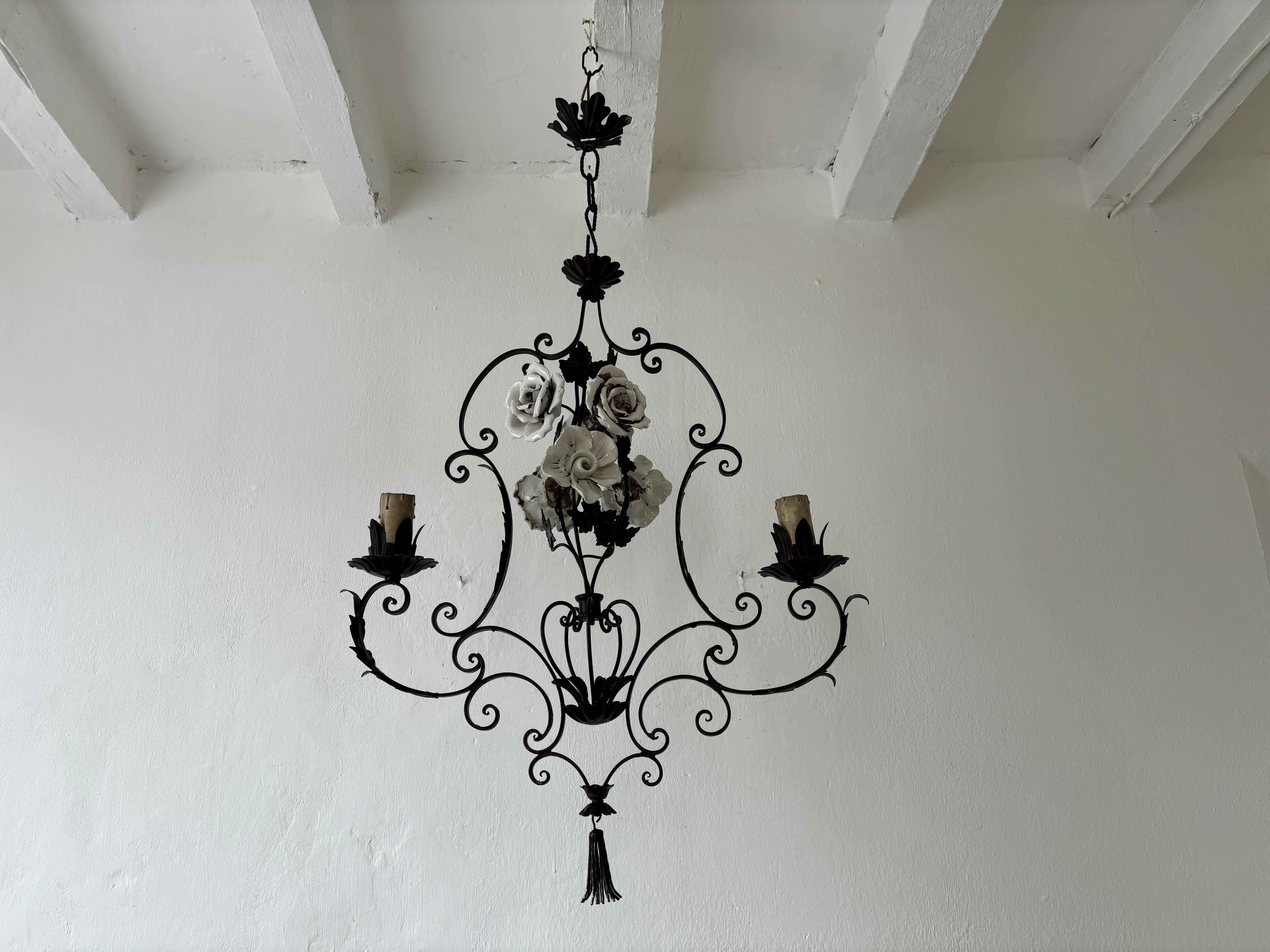 Housing 2 lights. Will be rewired with certified UL US sockets for the USA and appropriate sockets for all other countries. One of a kind chandelier. Hand forged wrought iron with handmade big white porcelain roses and metal leaves.  Also adorning a