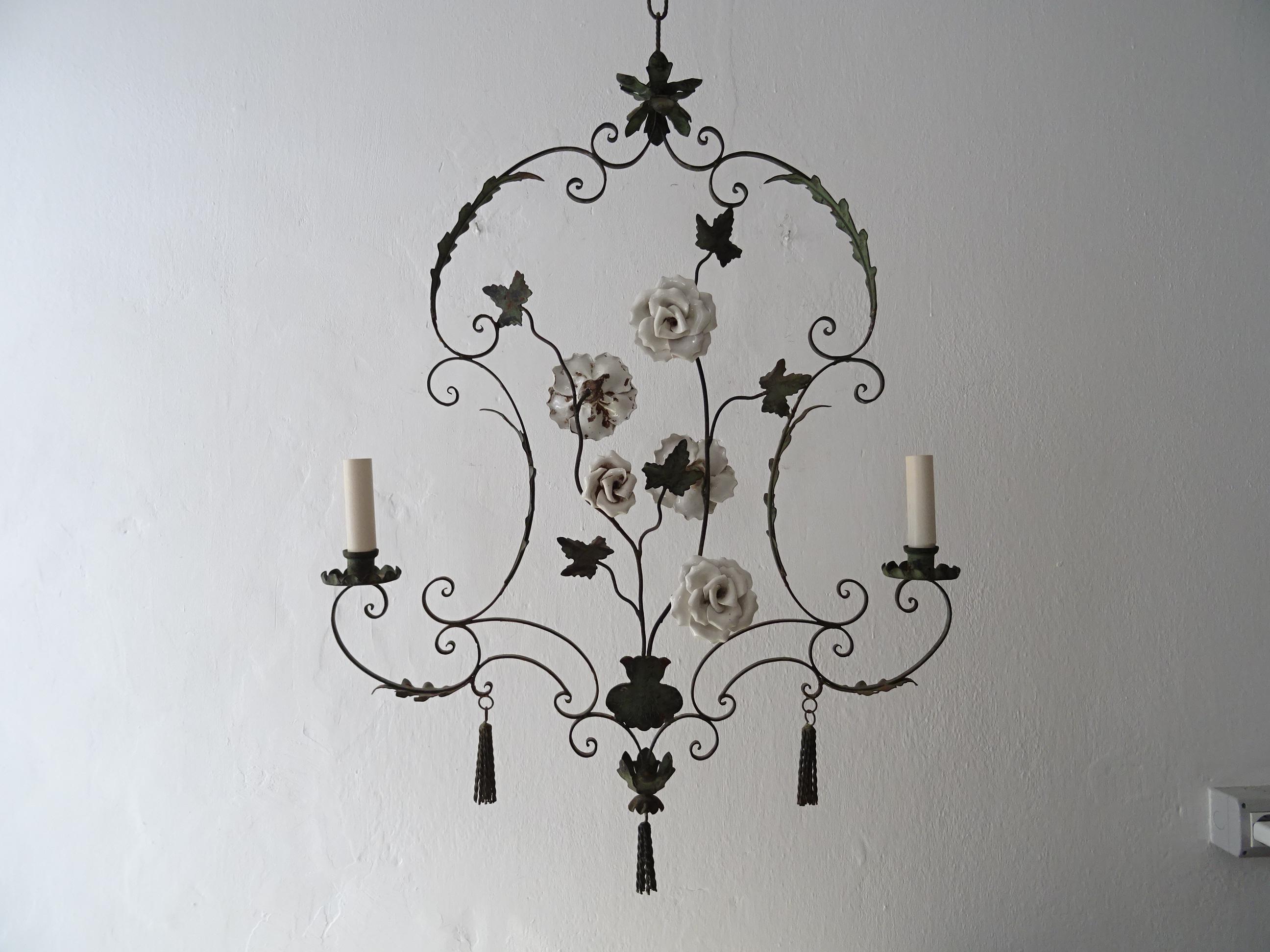 Housing 2 lights. Will be rewired with certified UL US sockets for the USA and appropriate sockets for all other countries. One of a kind chandelier. Hand forged wrought iron with handmade big white porcelain roses. Also adorning 3 tassels as
