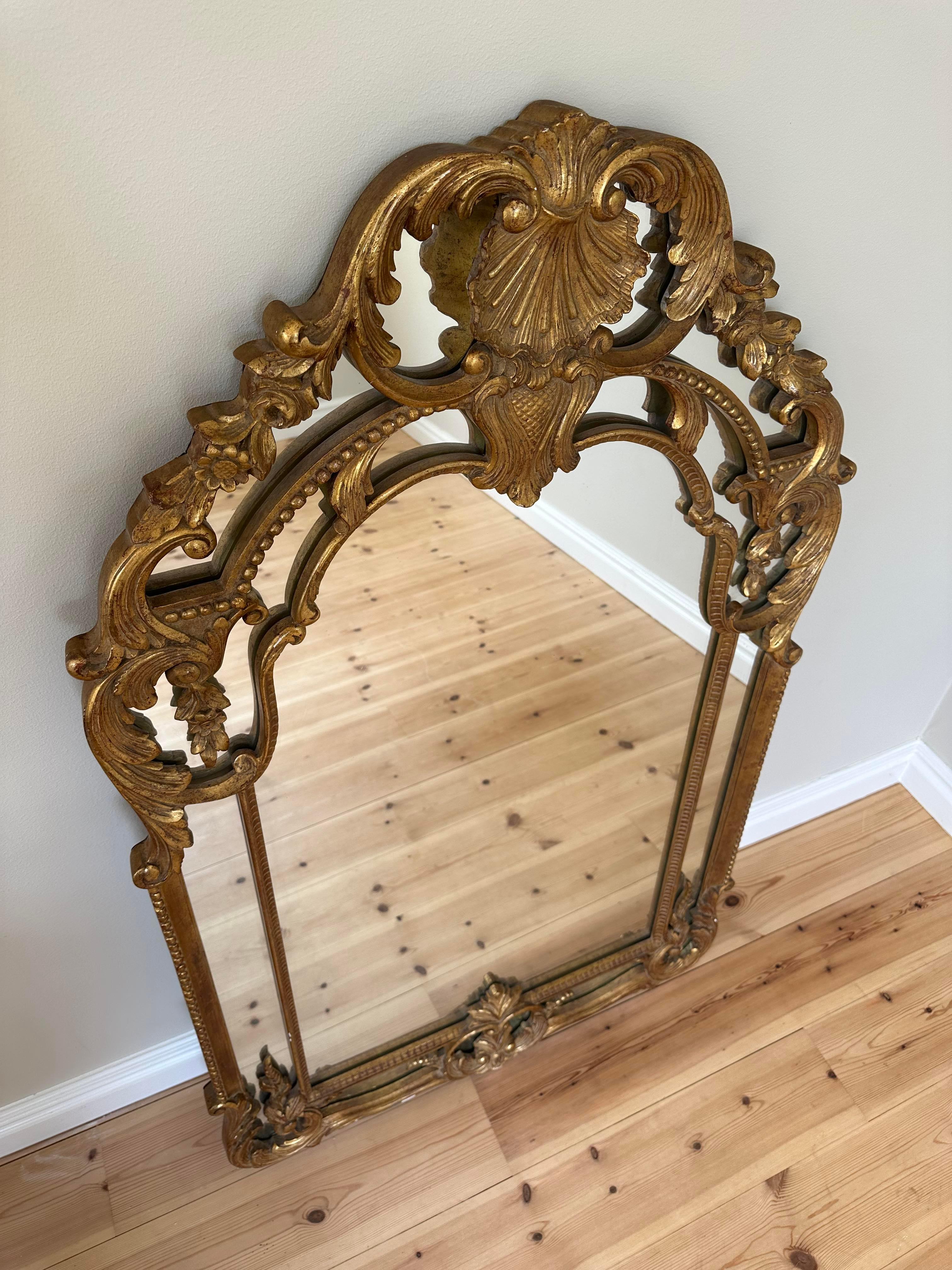 Grand miroir doré de style rococo. 