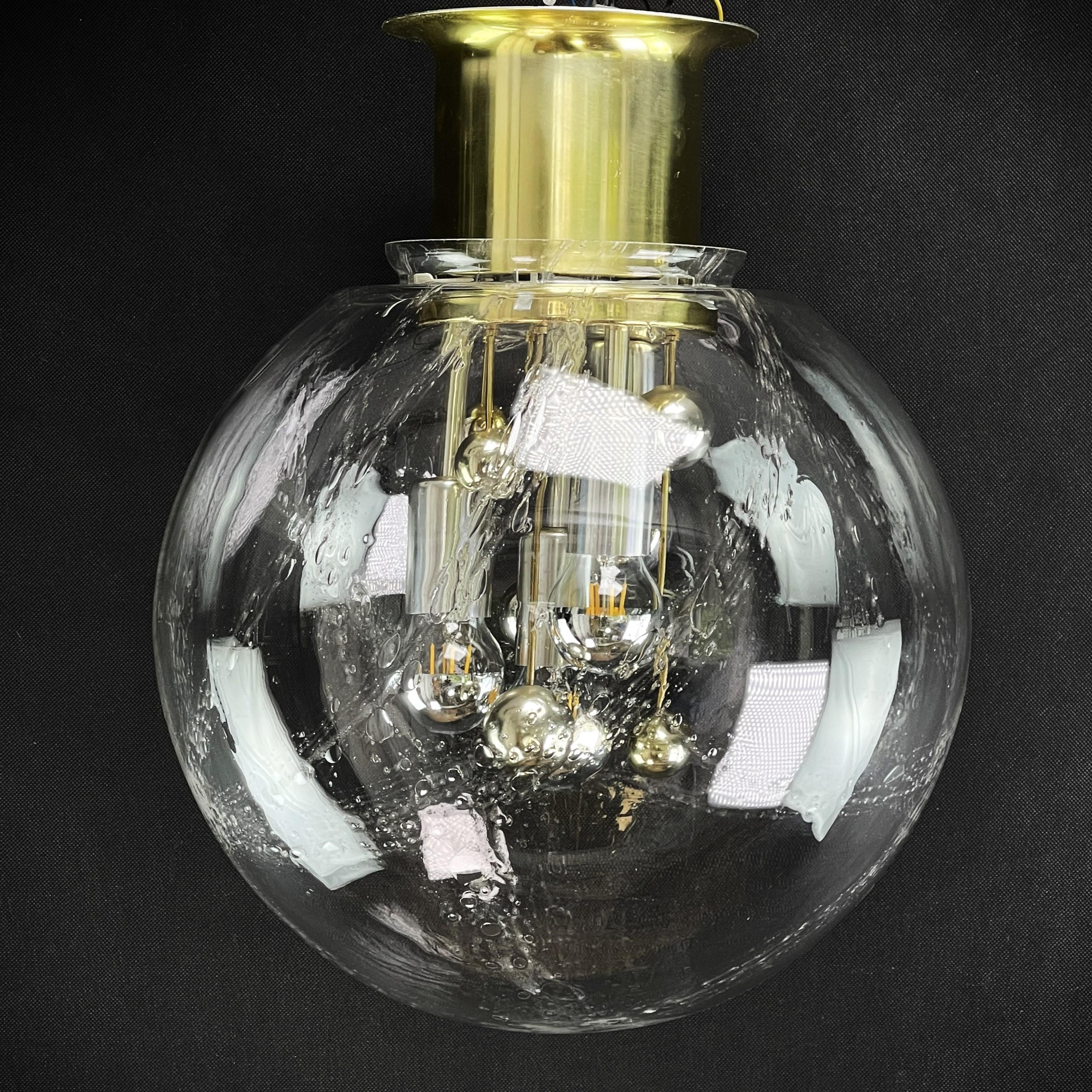 Doria Deckenleuchte mit großer Glaskugel

Die Designerlampe ist ein echter Klassiker aus den 70er Jahren. Die Lounge-Lampe von Doria ist ein Original und spendet ein angenehmes Licht. 

Die Leuchte ist aus Aluminium und Messing gefertigt und hat