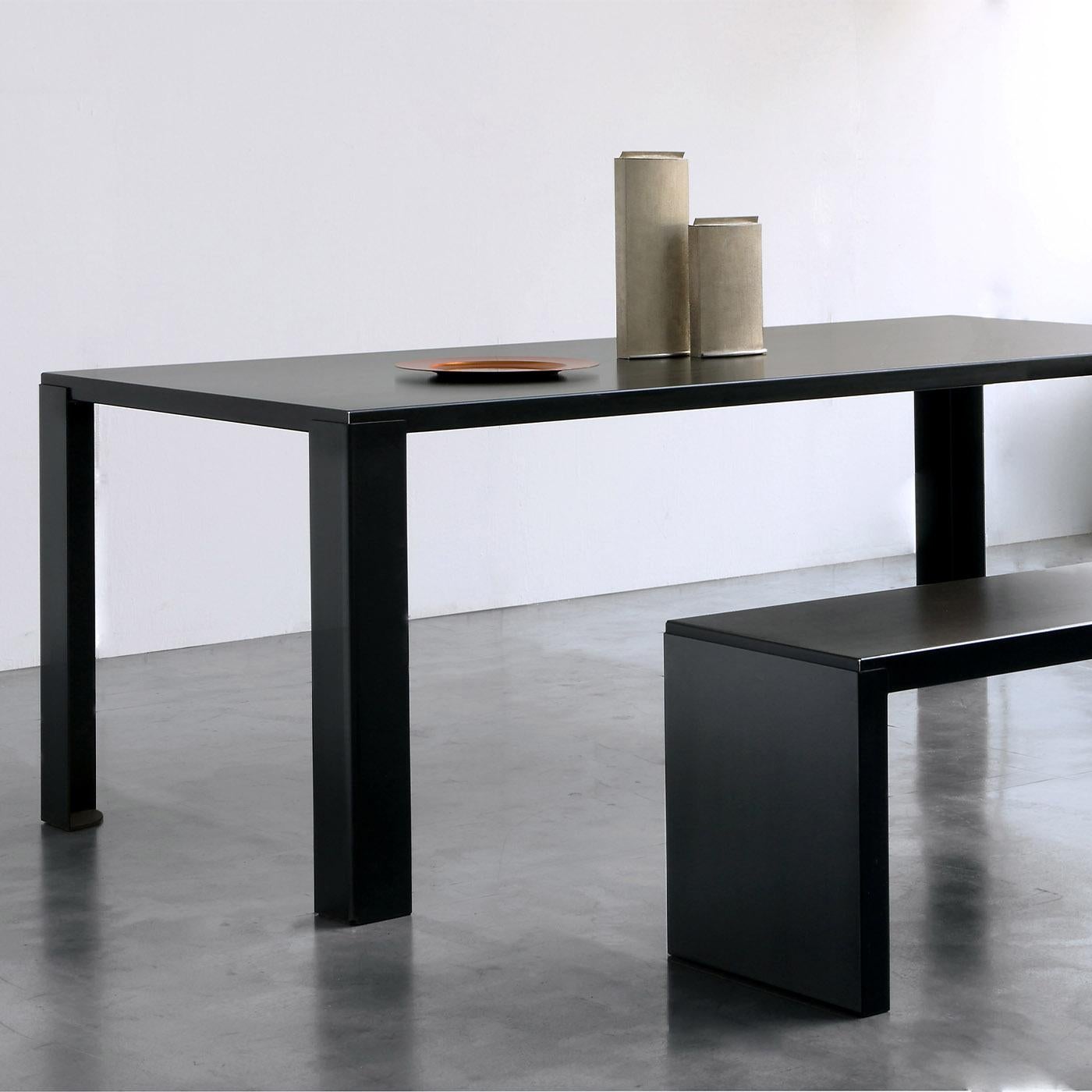Stunning in its unadorned simplicity, this wide rectangular table sports an utterly minimalist black-finished silhouette in steel sheet and decorated with phosphate. The legs (measuring 10x10cm) can be easily disassembled whenever desired. A layer