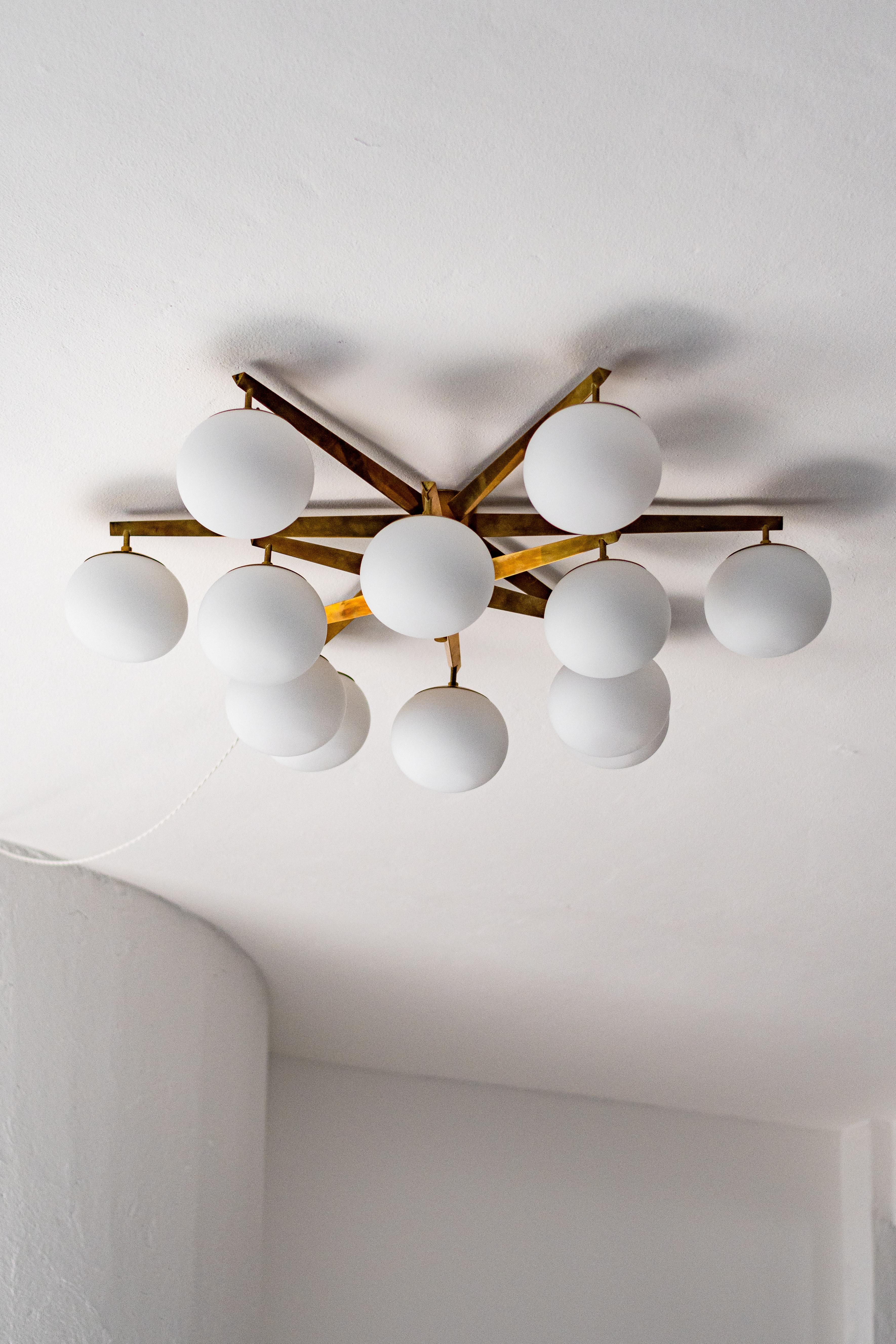 Grande lampadario decorativo - Lampada ad incasso in ottone - Lampadario italiano di metà secolo - Lampadario moderno in ottone 

Grande lampada da incasso italiana Mid-Century Modern in ottone, con dodici globi di vetro opalino. Un meraviglioso