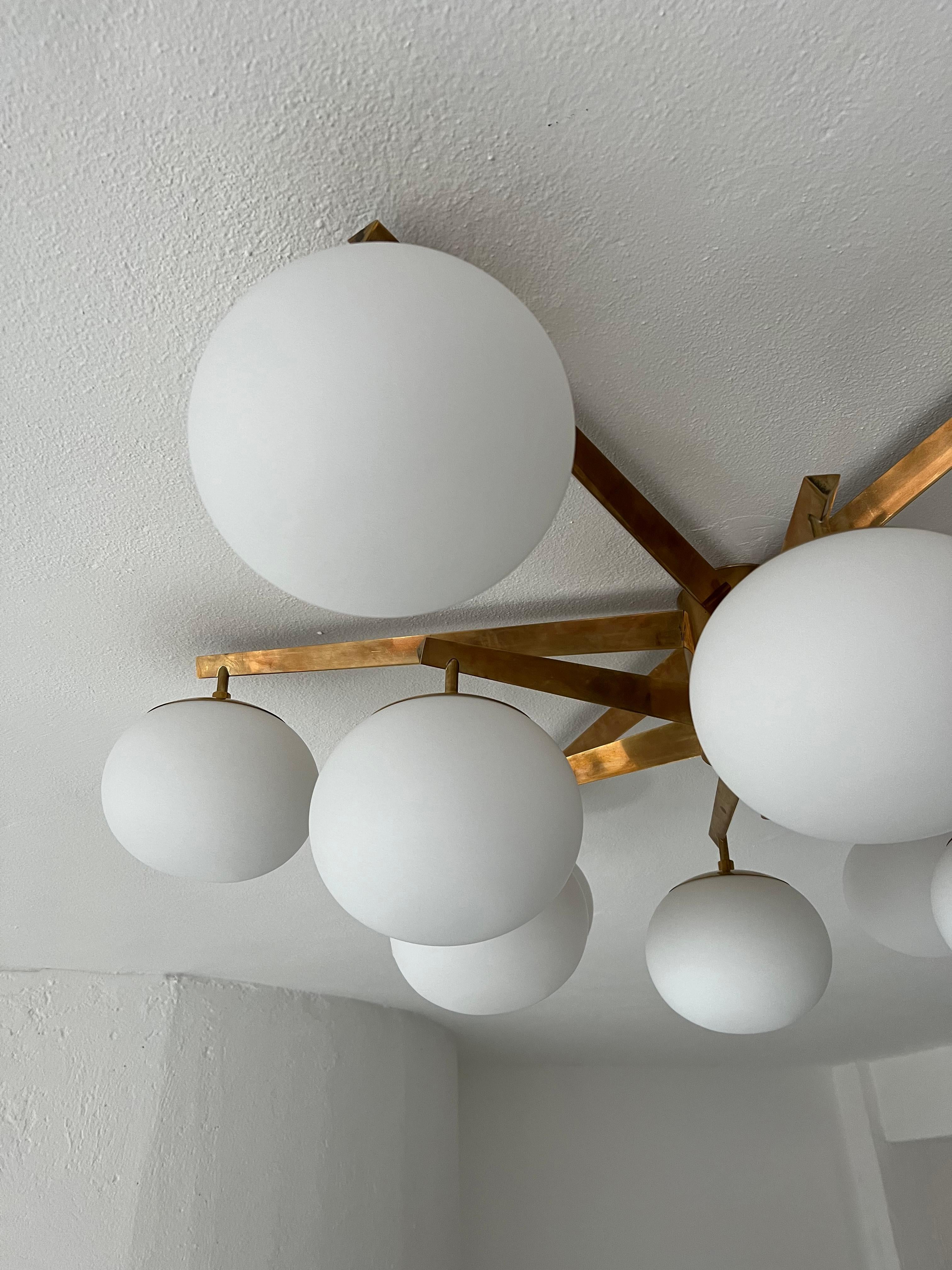 Big Decorative Chandelier - Flush Mount Brass Lamp - Italian Mid Century Modern Light

Big Italian Mid-Century Modern flush mount lamp in brass, with twelve opaline glass globes. A wonderful decorative chandelier that instantly conjures up a refined