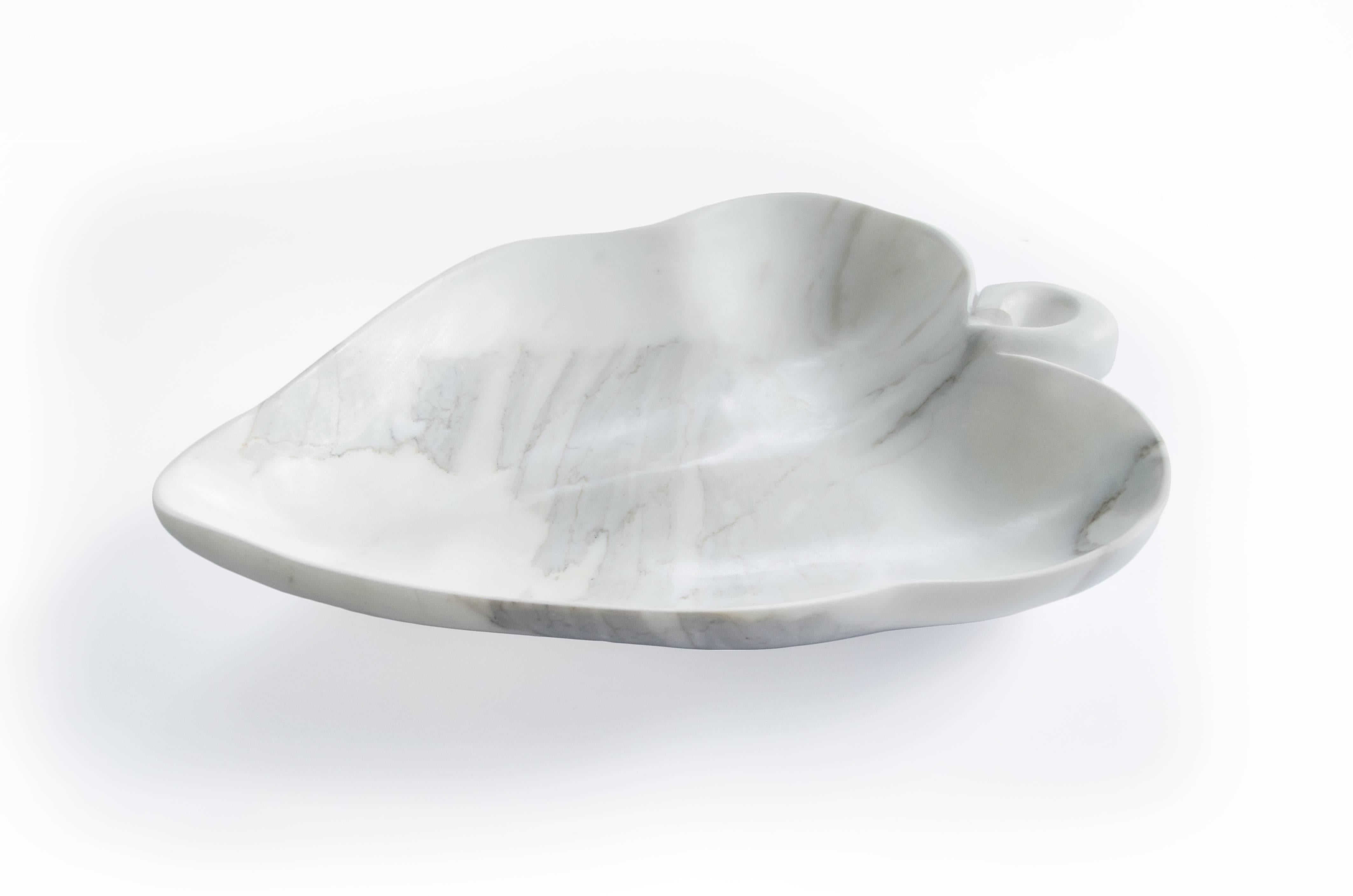 Big bowl in Calacatta marble with the shape of a leaf. Each piece is in a way unique (since each marble block is different in veins and shades) and handmade by Italian artisans specialized over generations in processing the famous Carrara marble.