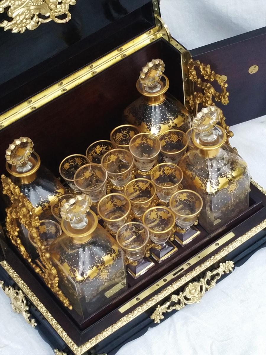 Stunning big size liquor cabinet cave à liqueur in blackened wood richly and beautifully decorated in gilt bronze. It opens to a mahogany interior with gilt bronze handlers and a gorgeous and rare complete set of Baccarat Crystal composed by 4
