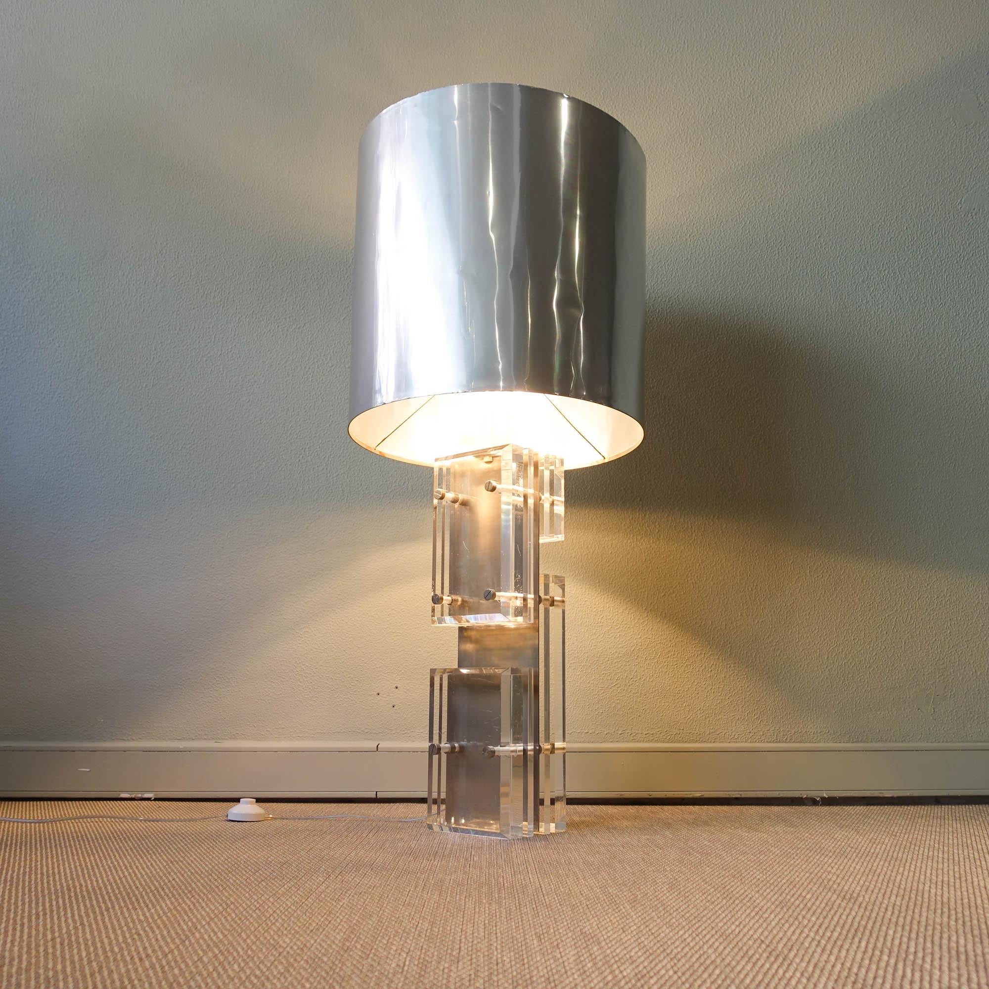 This big table / floor lamp was designed by Willy Rizzo for Noel B.C, in Italy, during the 1970's. 
The body is comprised of multiple pieces of Lucite attached to a central polished steel plate by rods and custom screw finials. The Lucite pieces