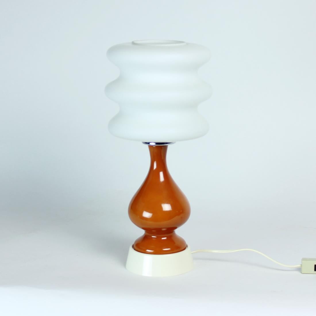 Beautiful table lamp from midcentury modern period. It looks like a work of art even when not lid up. Produced in Poland in 1960s by Polam Pila company. The lamp is made out of a ceramic body in dark orange/brown color which stands on a cream/white