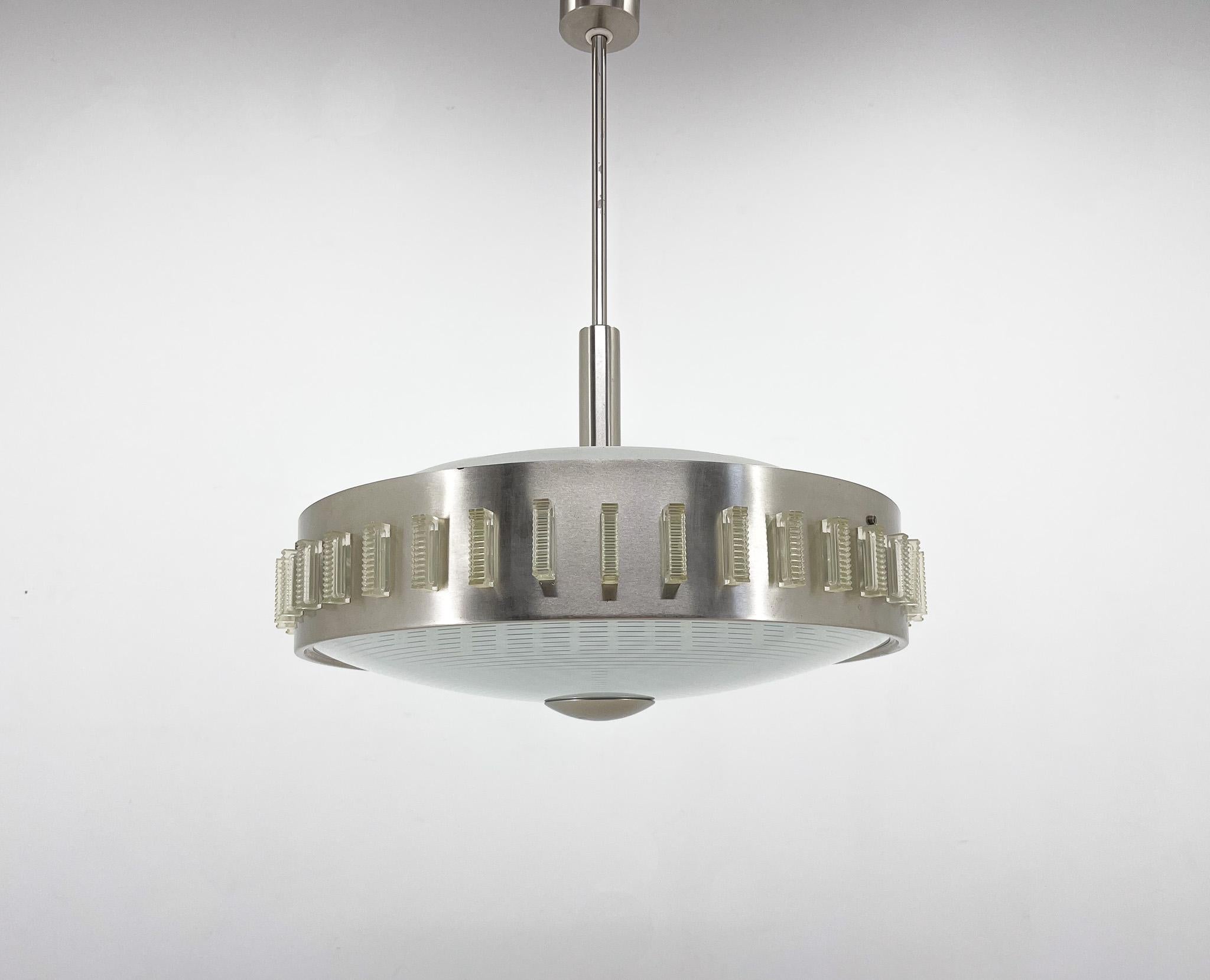 Vintage pendant light made of metal glass and plastic. The plastic vertical rectangles around the perimeter of the chandelier can be easily removed and the light will shine directly through the metal strip.