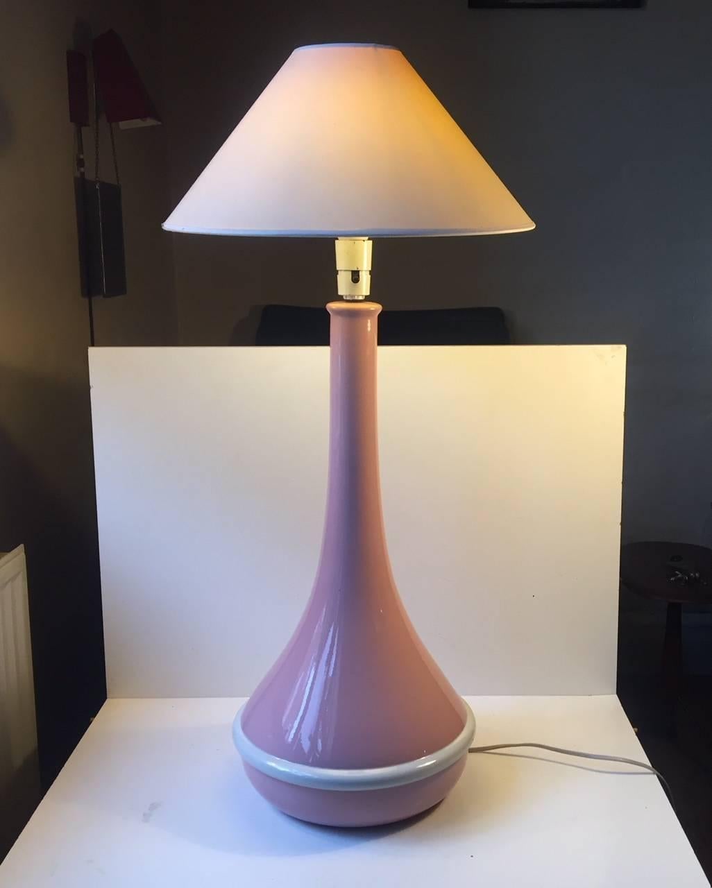 Very large and fully glazed Faience table lamp. Besides the white ribbon its pink - very pink. It features an on/off switch to its socket. It was manufactured and designed in-house at Royal Copenhagen in Denmark during the 1970s. Its very rare and