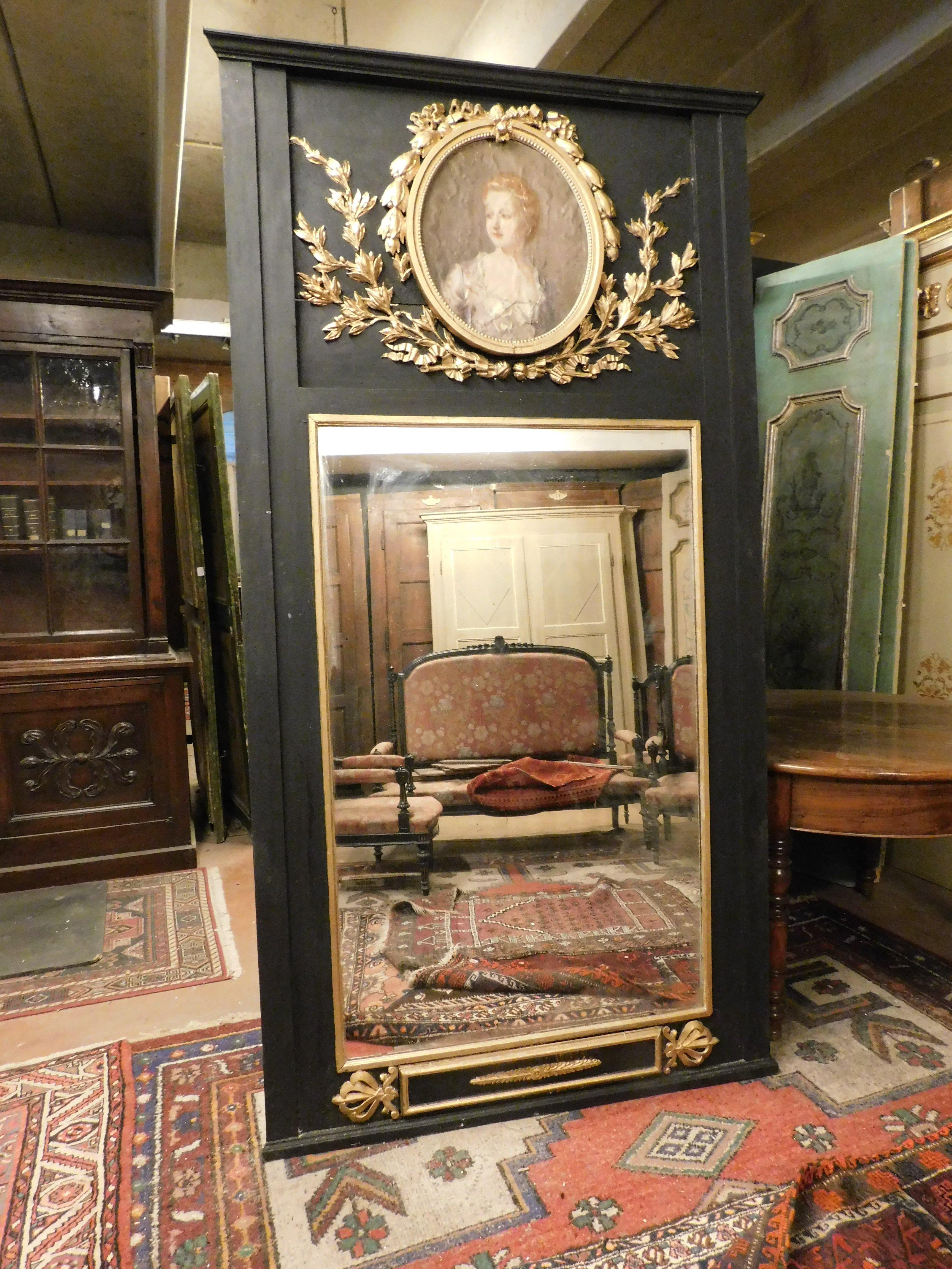 Ancient and large mirror, for fireplace or wall, carved in wood and lacquered on a black background, enriched with gilded carvings and painting depicting the female figure of a lady, tempera on paper, built in the 19th century in Italy, retro and