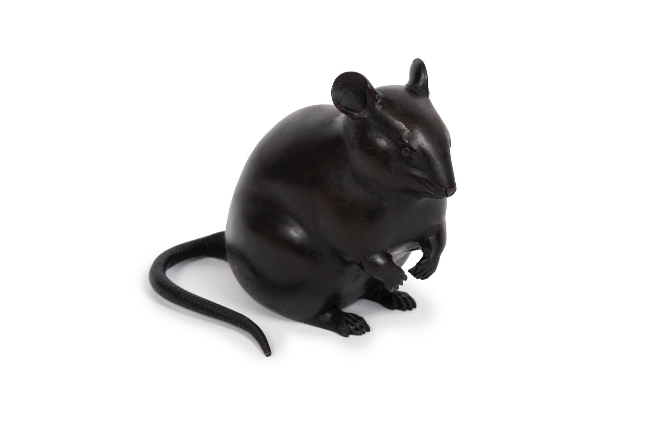 Immense sculpture d'un rat à la patine brun foncé, dont la pose renforce le schéma. 
traitement. Sa tête simple et sa moustache à peine dessinée, son corps lisse et rebondi 
corps et la queue très détaillée, enroulée sur son côté droit, confèrent à