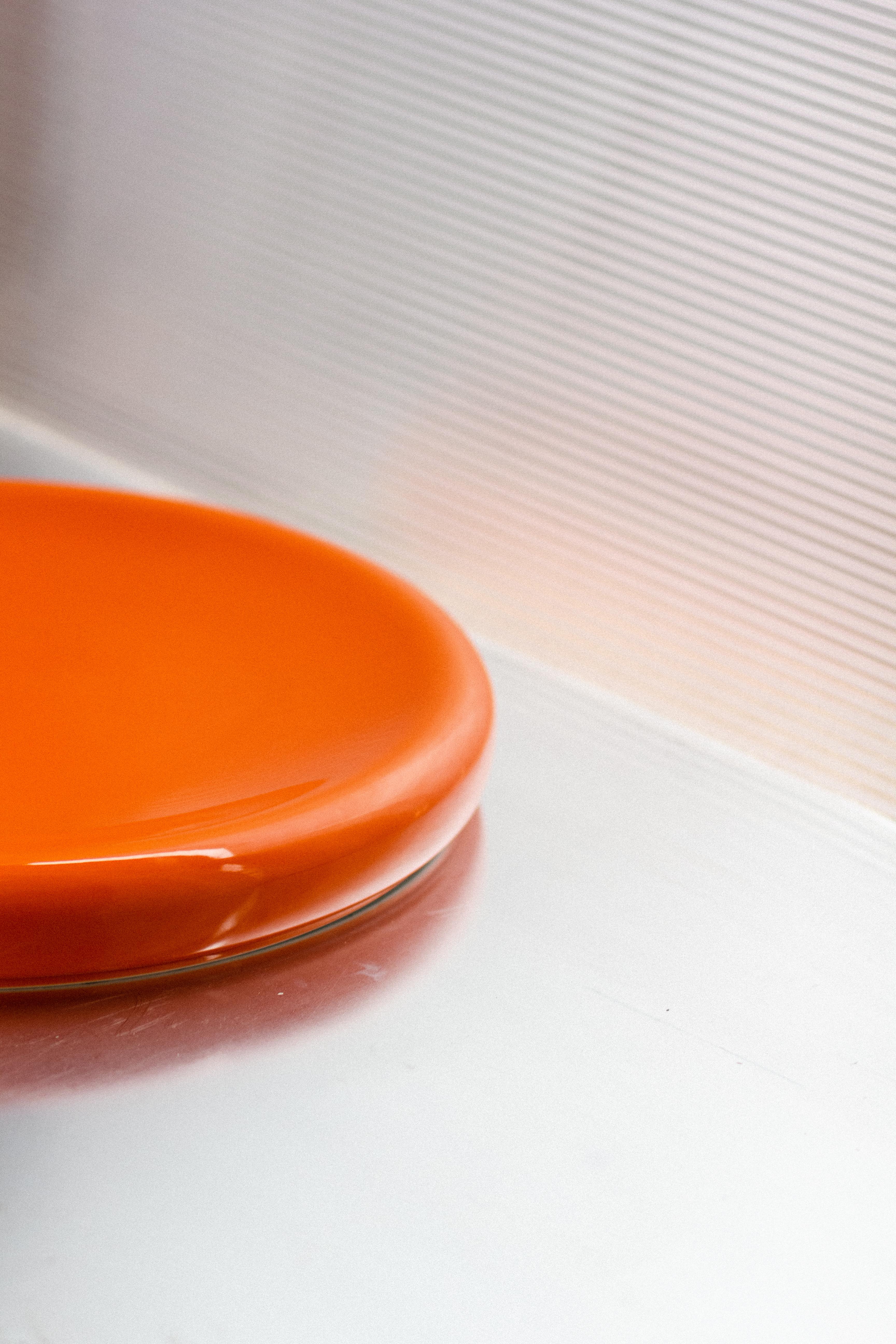 Big O plate is a big rounded deeply glazed porcelain serving platter. 

The platter is intended to be used to serve food or if you like as a display on your table etc.
In this first edition, we make it in a bold orange and a more subtle sand