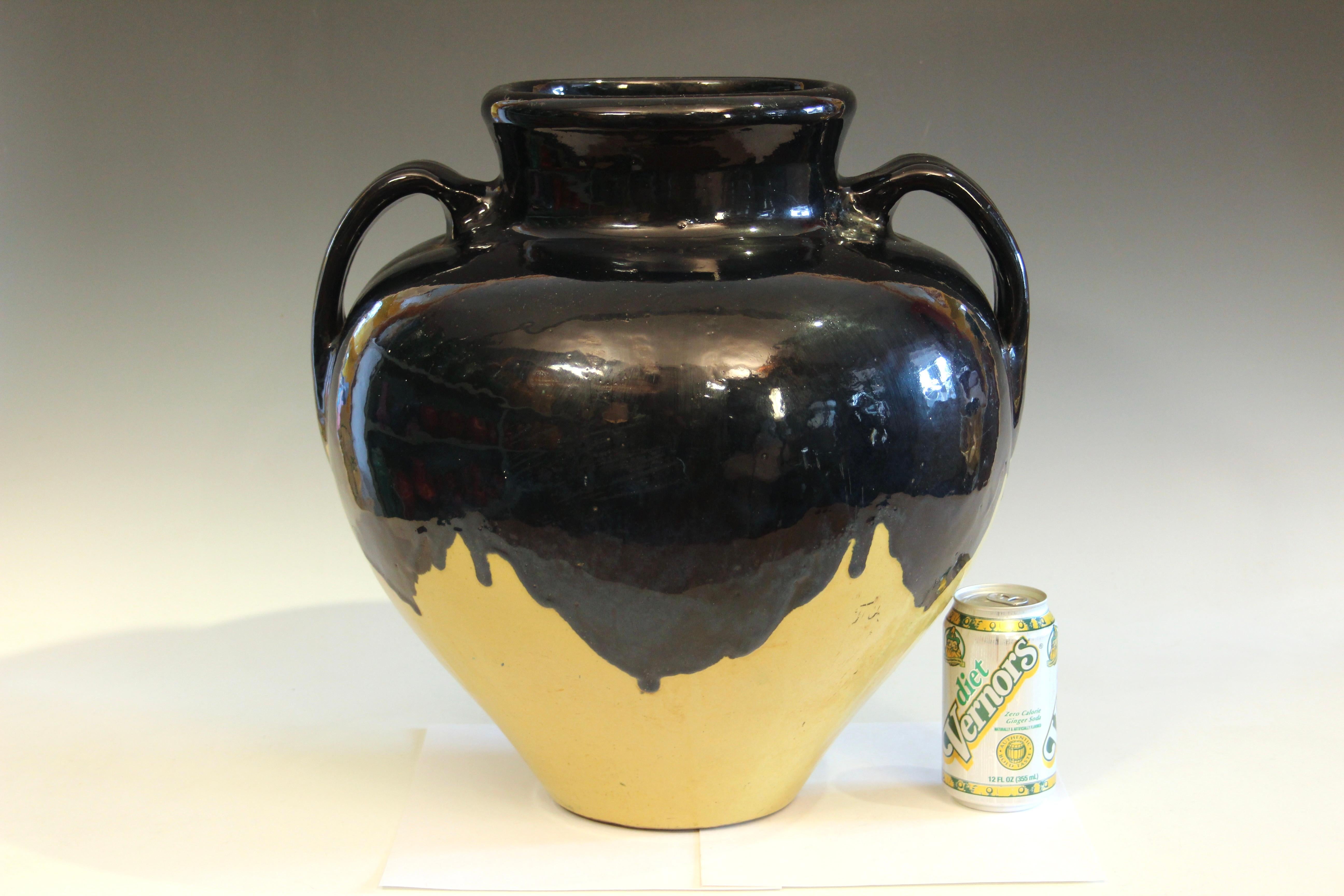 Old Arts and Crafts Zanesville Ebonello vase with black/midnight blue over tan yellow glaze, circa early 20th century. Passages of blue flambe in the black glaze. Approx. 16
