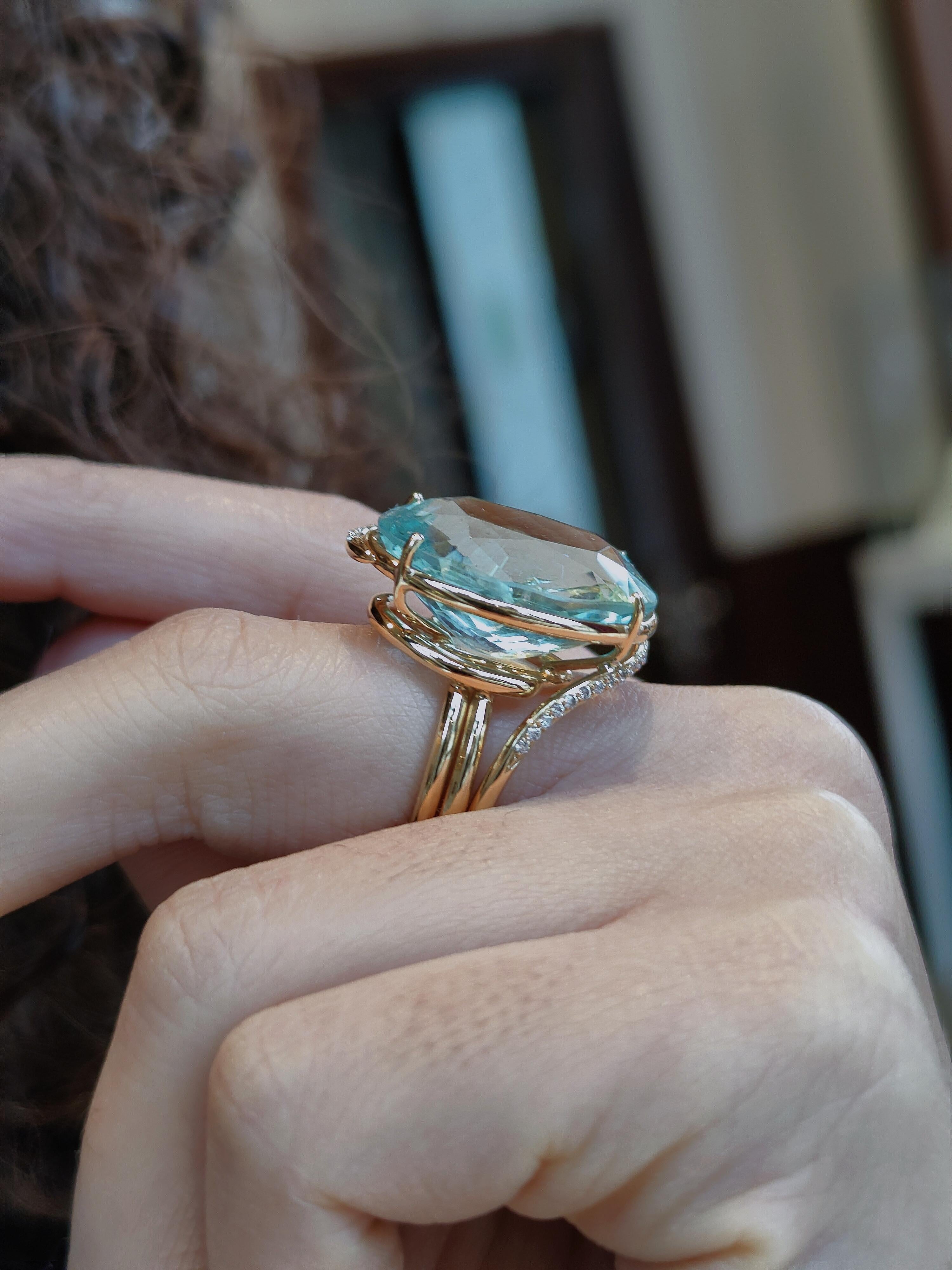 A lovely large 24.58ct oval aquamarine from Africa is set with two diamonds in this pretty 18k yellow gold ring. This natural blue coloured aquamarine with sea green highlights measures 22x 17mm.
Some natural inclusions are visible but do not