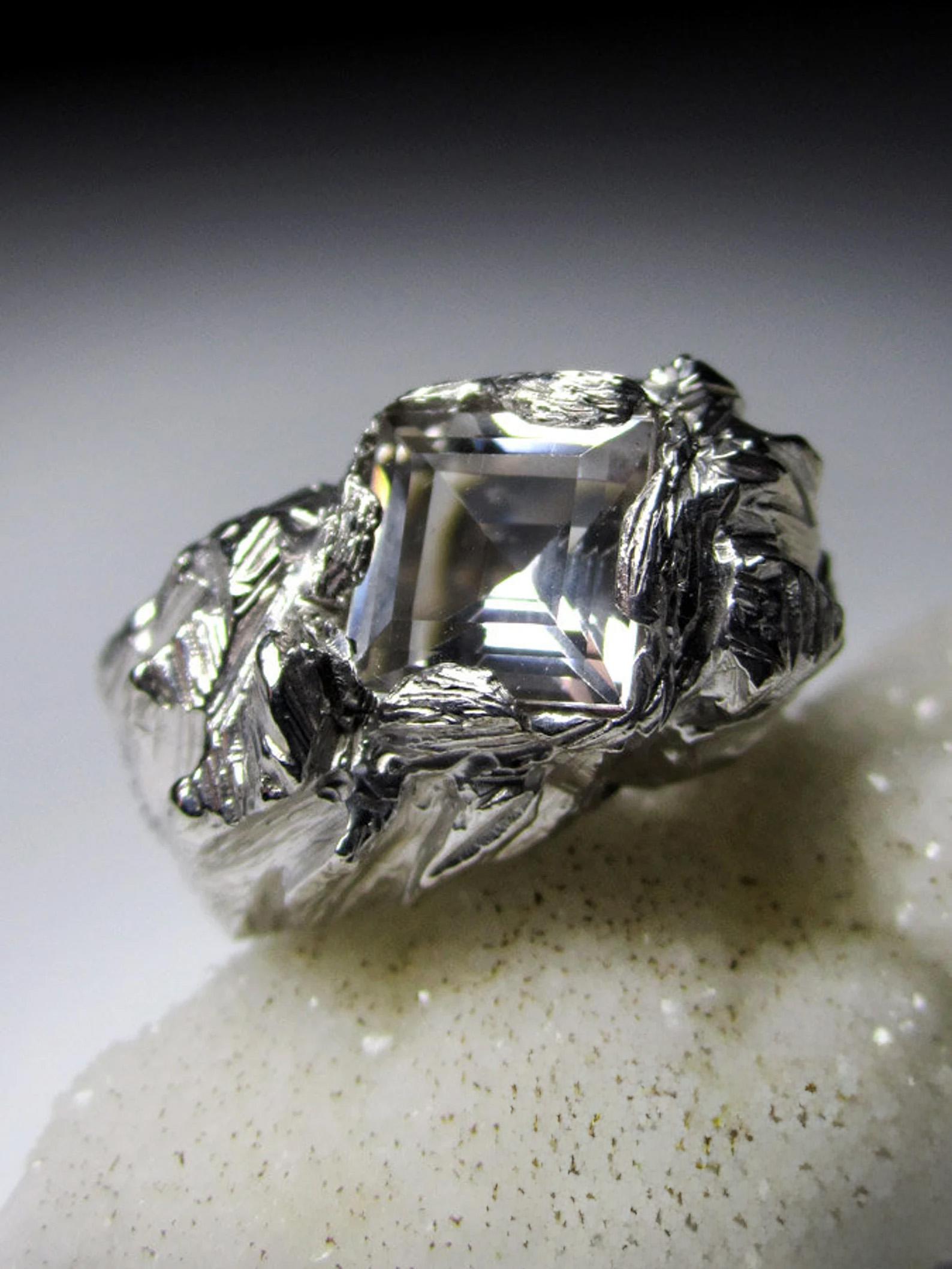 Grande anello d'argento con cristallo di rocca naturale con taglio quadrato e fantasia.
origine della pietra - Brasile
misure della pietra -  0,16 х 0,31 х 0,31 in / 4 х 8 х 8 mm
Peso della gemma - 2,65 carati
Peso dell'anello - 10,62 grammi 
misura