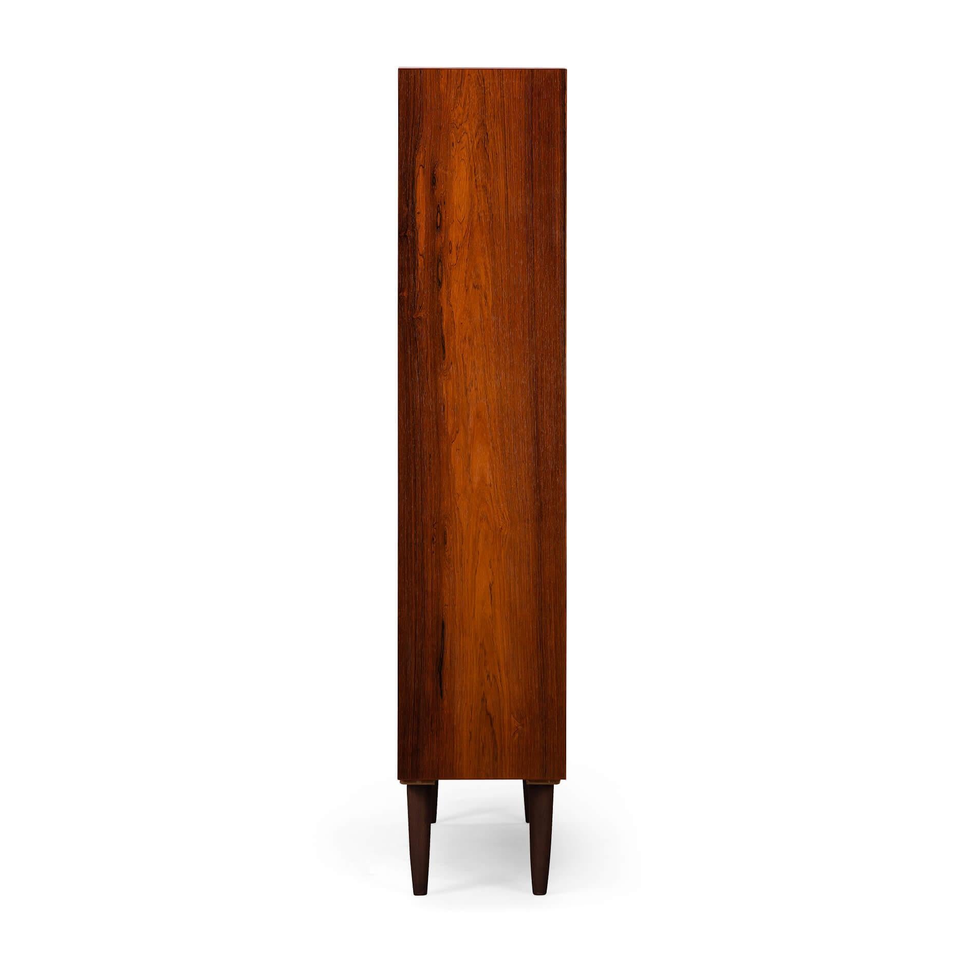 Danish Design
This stunning Danish Design Hundevad Bookcase from the 1960s is a timeless piece of furniture. It is crafted from rosewood, a durable and beautiful Material that is known for its warm tones and intricate grain patterns. 

The