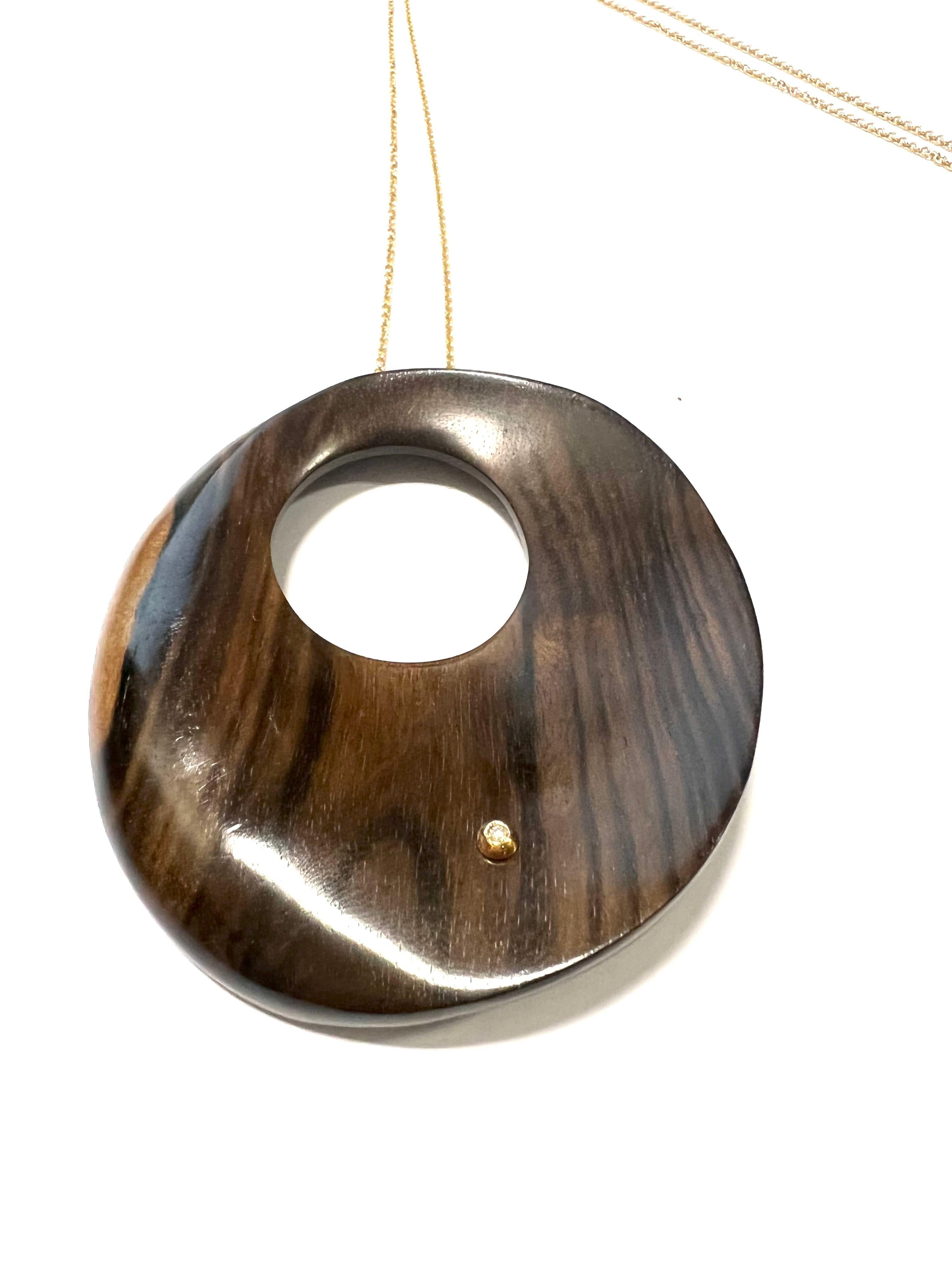 Big Round Rosewood Pendant With Hole And Diamond On 18K Yellow Gold Necklace
Rosewood is an elegant and precious wood and this pendant is embellished by a diamond.

Tot weight gr. 55.3
Gold weight gr. 12.8
1 Diamond GVVS ct.0,09
Chain length