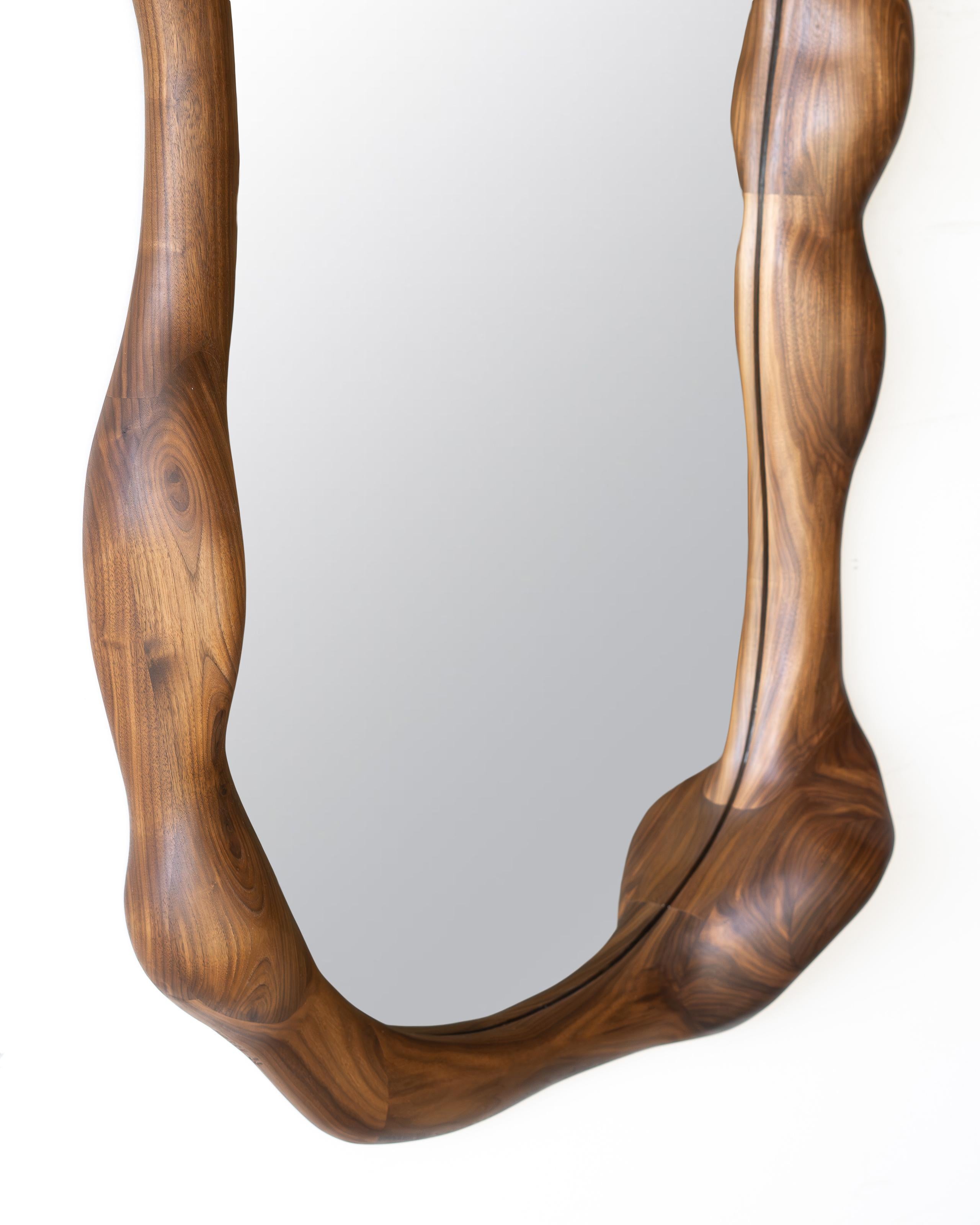 Le cadre du miroir est façonné à l'aide de divers outils manuels, ce qui rend chaque pièce unique avec son propre grain de bois distinctif. Il est fabriqué en bois de noyer de haute qualité et fini avec une huile à base de cire dure. 

Le miroir est