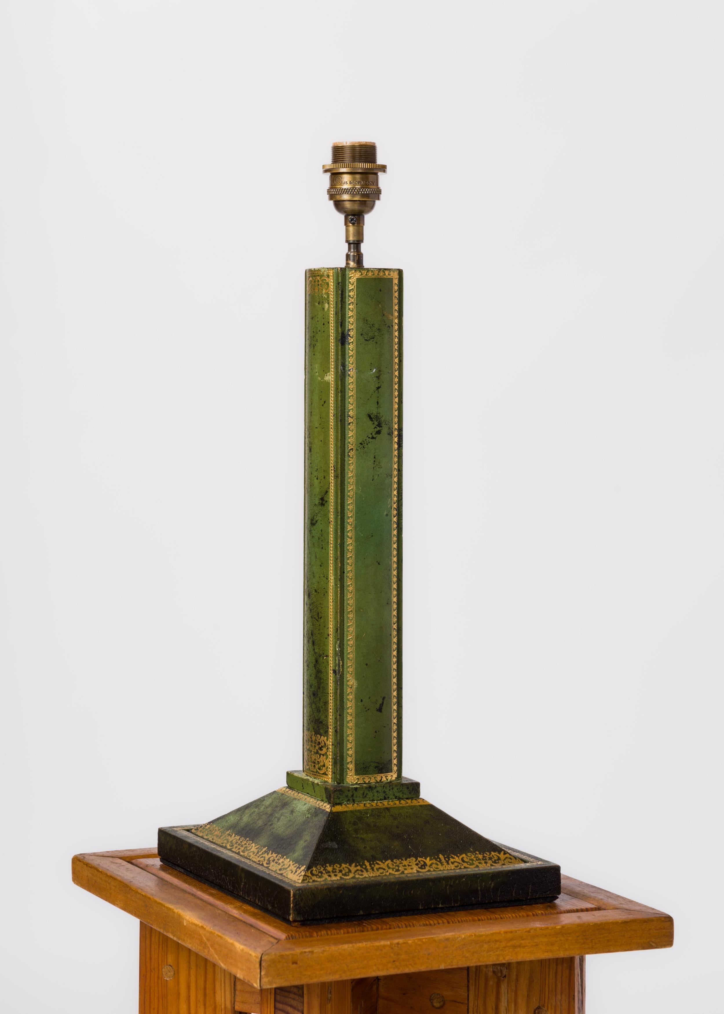 Lampe de table de grande taille en cuir vert parisien chic sur structure en bois, décorée de feuilles d'or. A la manière de Chalmette Malsherbes Paris.
La lampe a été recâblée pour être utilisée aux Etats-Unis.
L'abat-jour n'est utilisé qu'à des