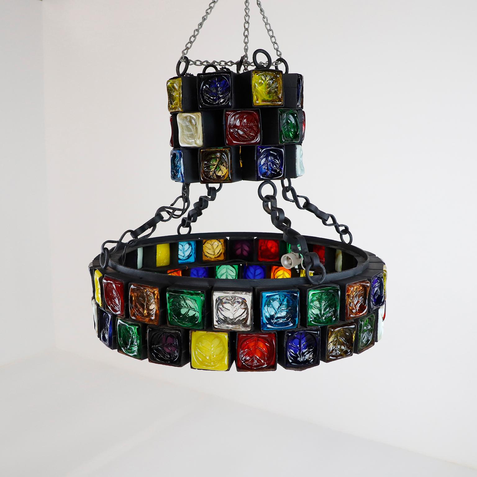 This chandelier is one of the most stunning samples of Brutalist art, made of steel and multicolored blown glass, each cube is handwrought in steel which cradles the thick sculptured glass, the big chandelier have 48 cubes of glass measures 6 x 6 cm