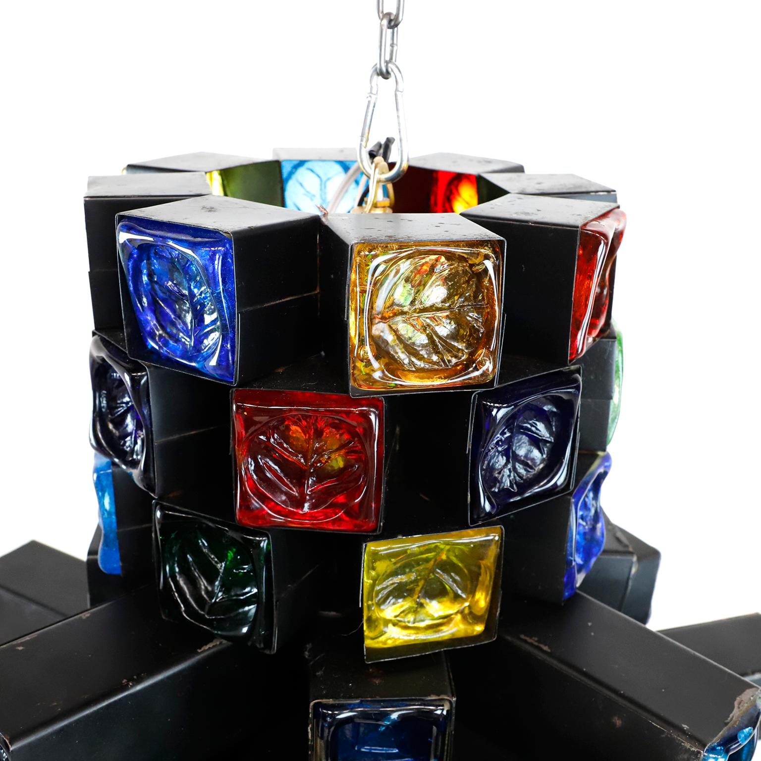 This chandelier is one of the most stunning samples of Brutalist art, made of steel and multicolored blown glass, each cube is handwrought in steel which cradles the thick sculptured glass, circa 1970, totally rewired and original porcelain sockets.