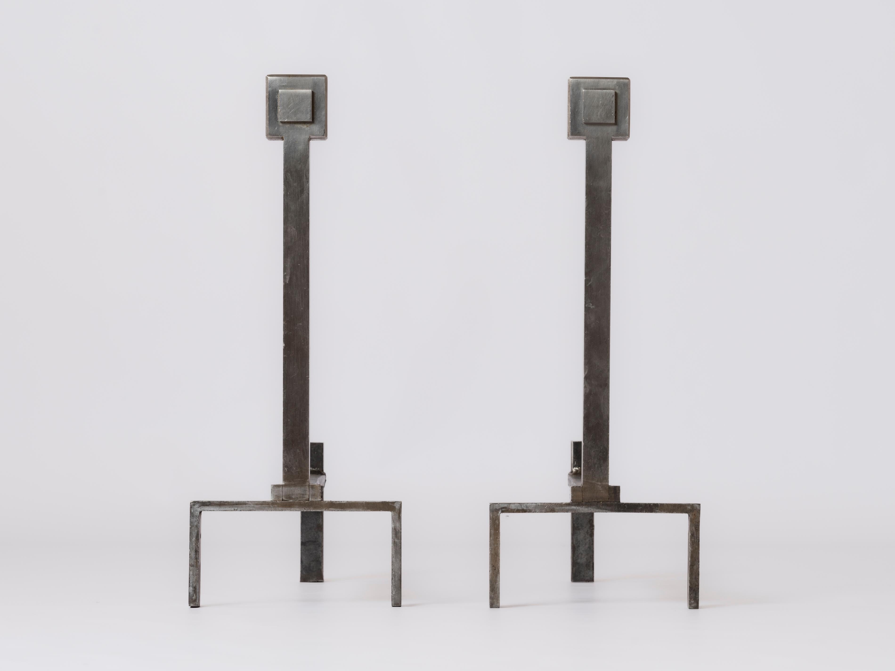 Graphic pair of minimalist stainless steel andirons in the style of Adnet or Xavier Féal. These sleek vertical firedogs are made of solid stainless steel and feature a 