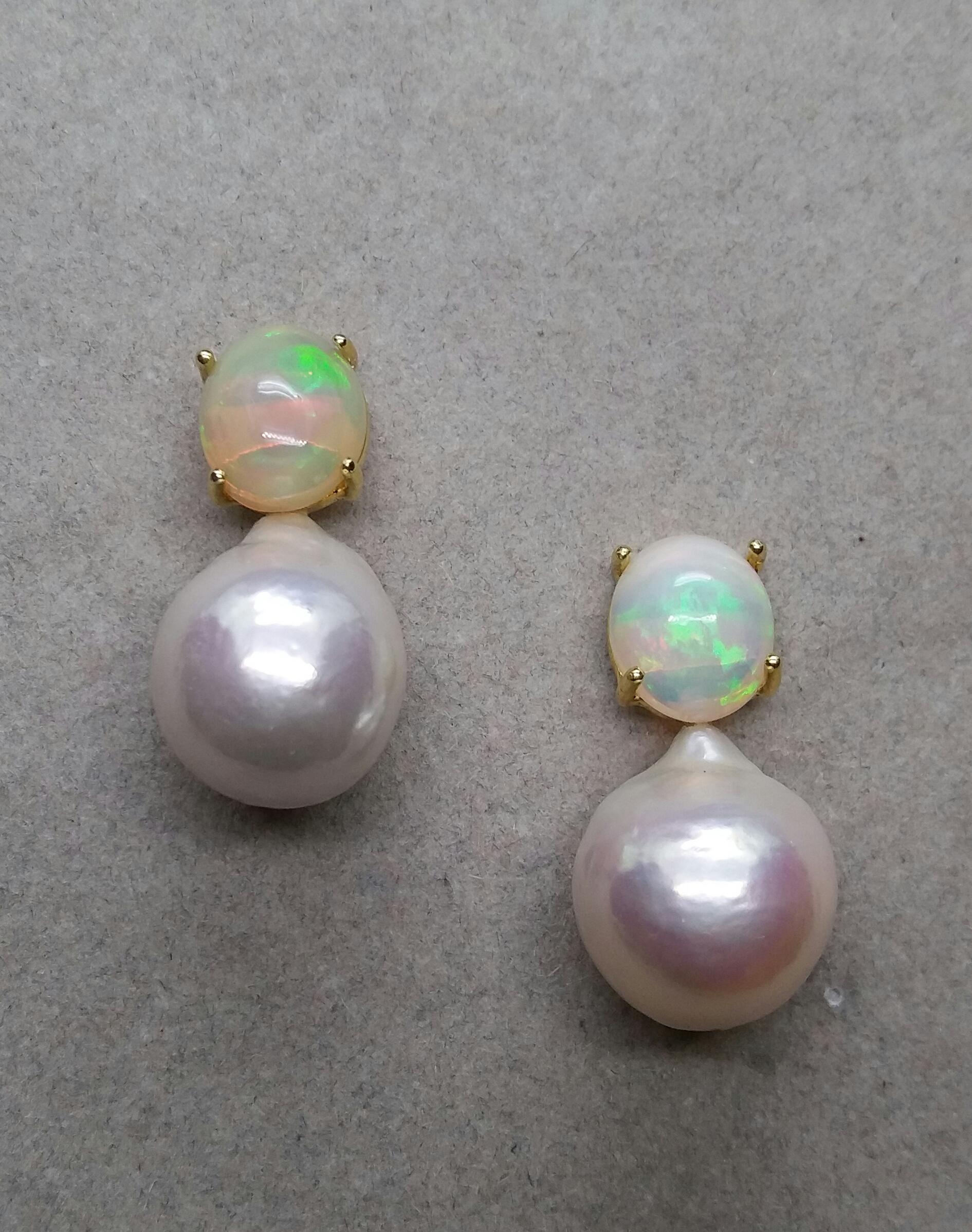 Simple chic stud earrings with a pair of Oval Solid Opal Cabs measuring 9 x 11 mm set in solid 14 Kt. yellow gold on the top and in the lower parts 2 unusual big size and excellent luster White Baroque Pearls measuring 14 x 17 mm and weighing 57