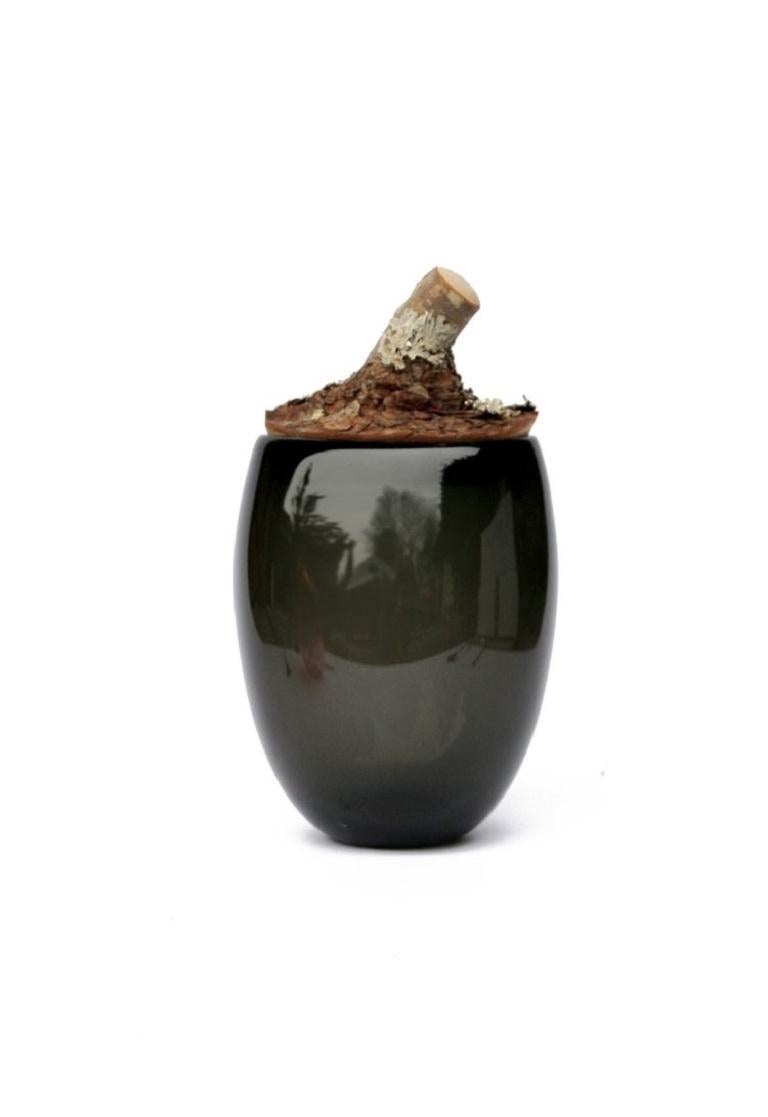 Big Smoke Branch Bowl, Pia Wüstenberg.
Dimensions: D 18 x H 27.
Materials: glass, wood.
Available in other colors.

A playful jar, with a lid made from a branch stub following the curvature of the glass. Branch Bowls are blown without a mould: